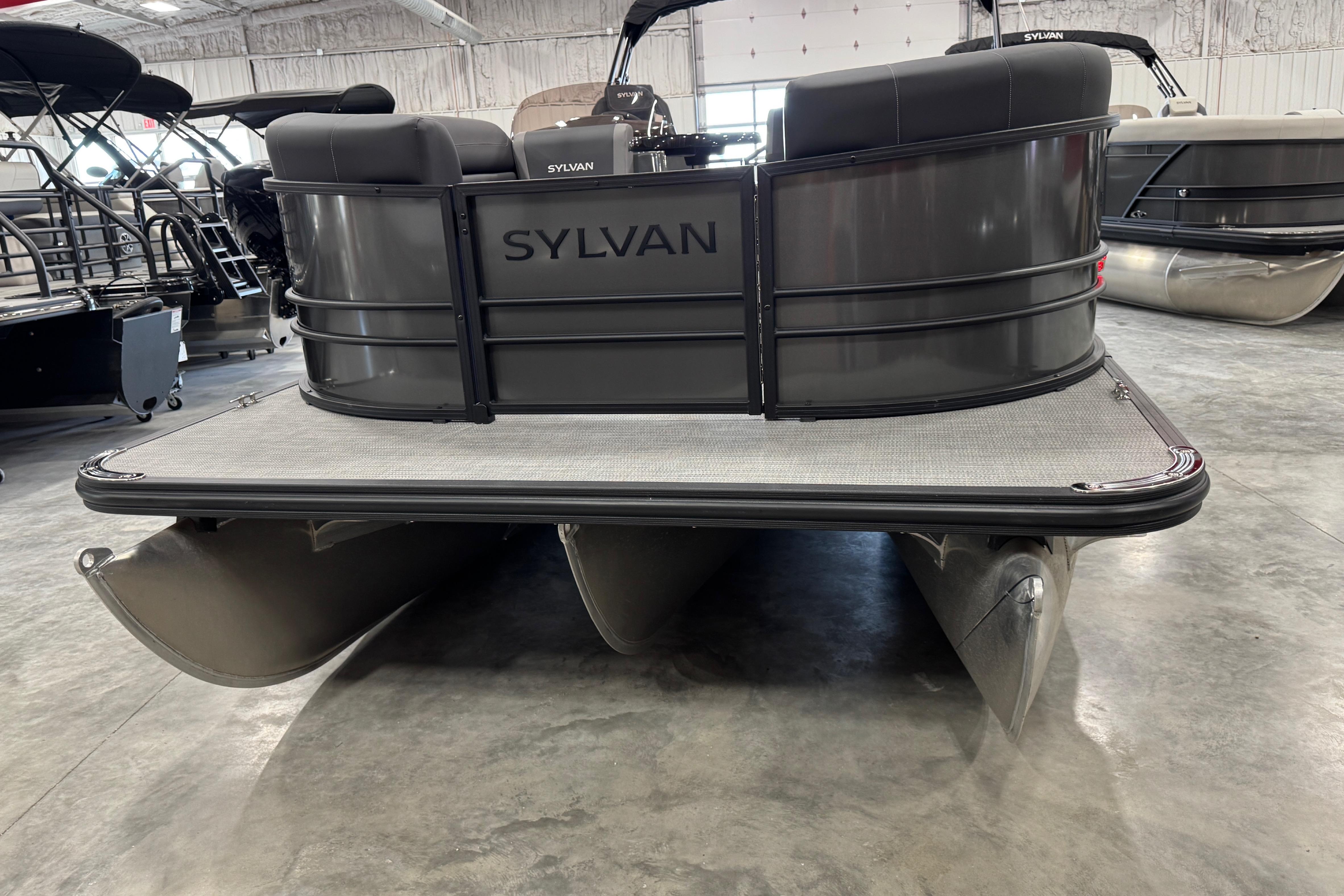 2026 Sylvan X5 pontoon boat in showroom, rear view showcasing sleek design.