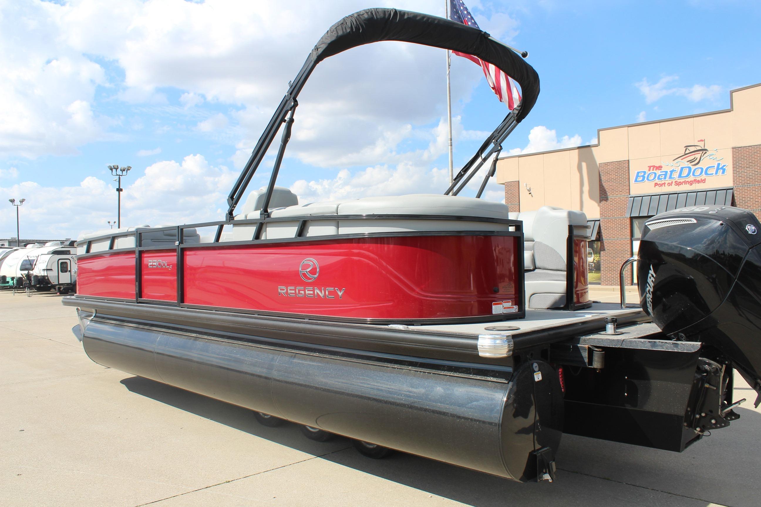 2025 Regency 230 DL3 pontoon boat with red exterior at dealership, clear sky background.