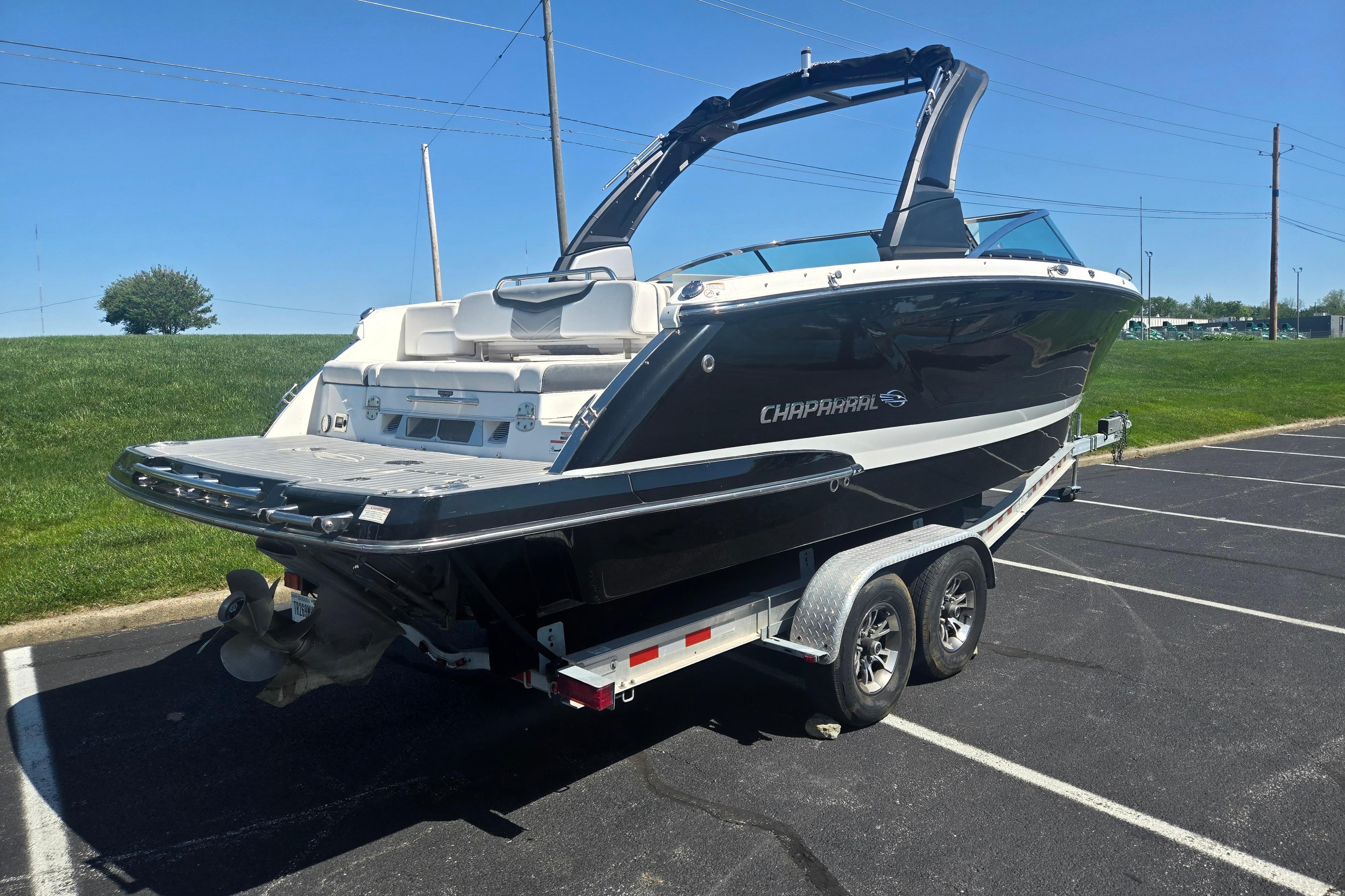 2018 Chaparral 267 SSX boat on trailer in parking lot, sunny day.