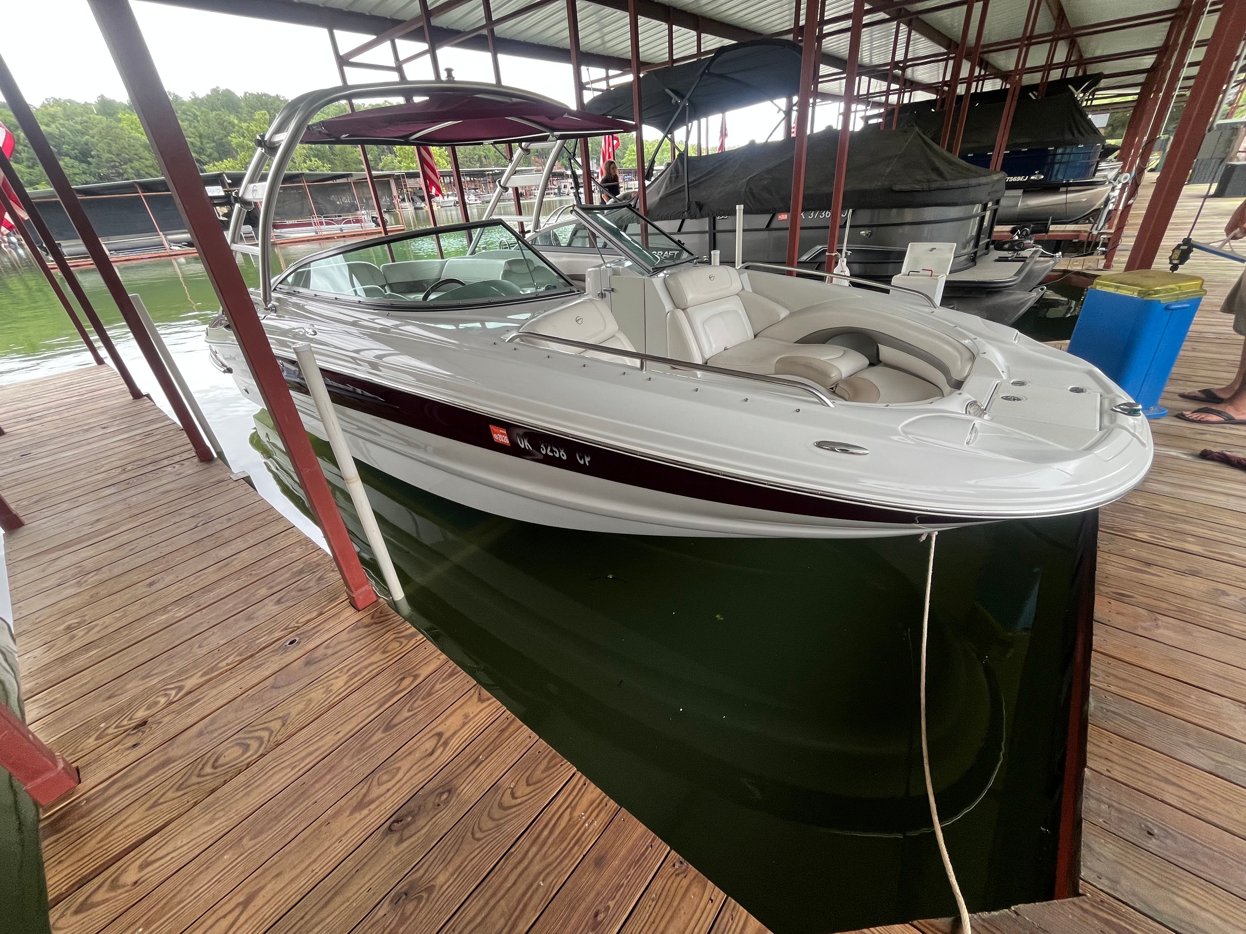 A 2008 Crownline 252EX boat docked under a covered area.
