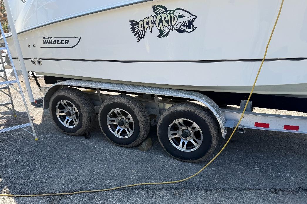 2023 Boston Whaler 250 Outrage on trailer, featuring "Off Grid" graphic.
