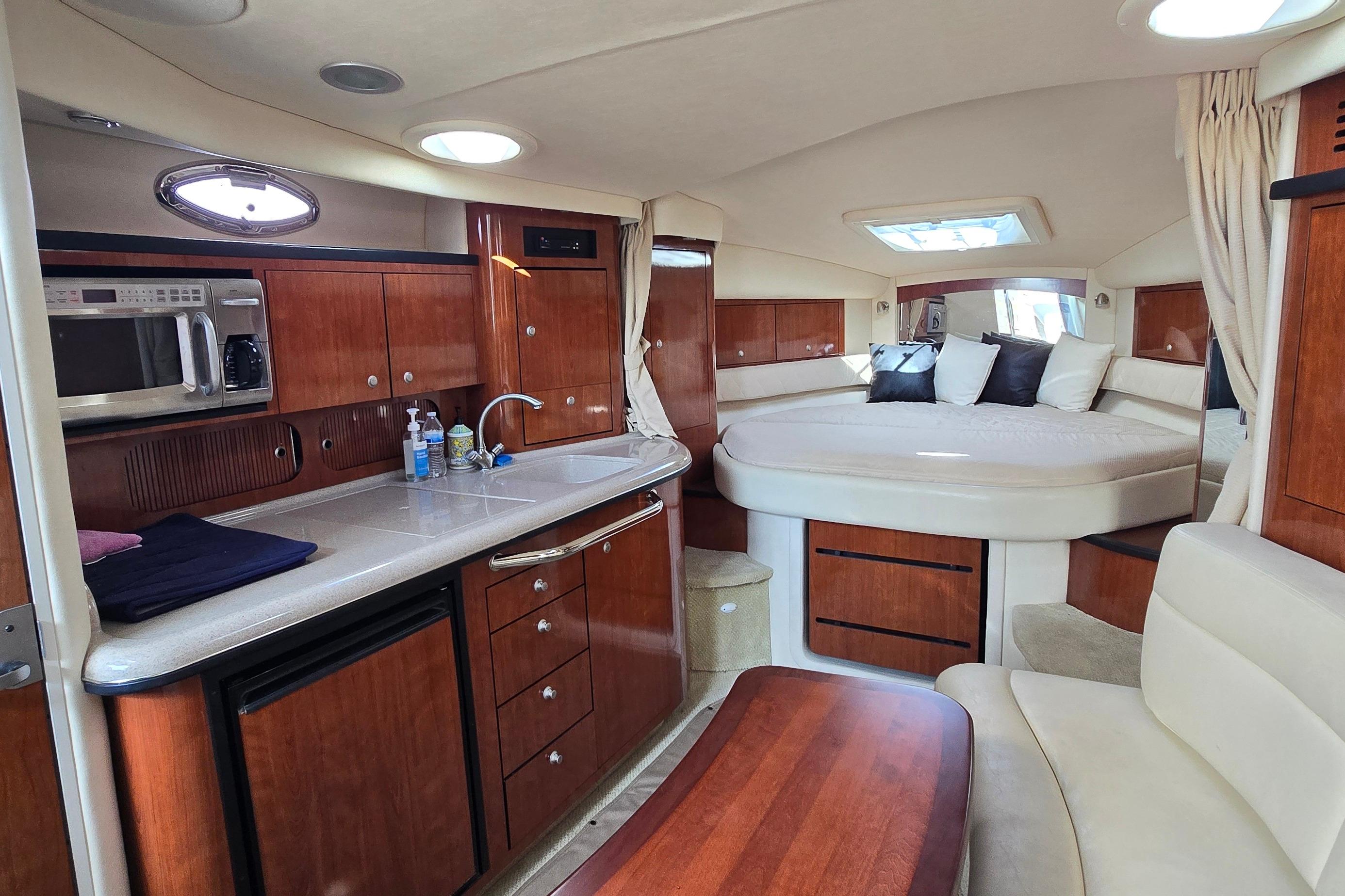 Luxurious interior of a 2007 Sea Ray 340 Sundancer yacht with kitchen and cozy sleeping area.