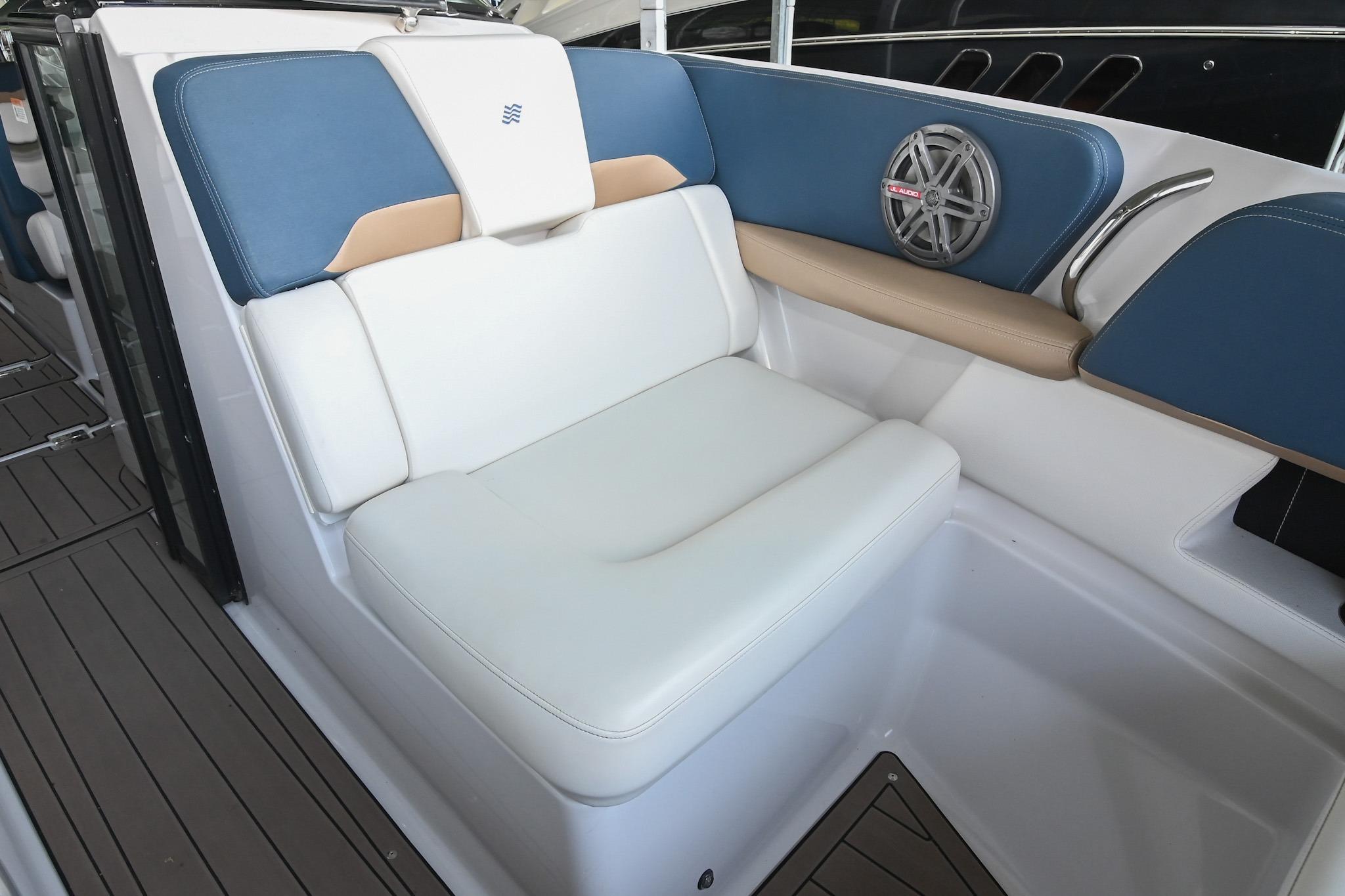 2014 Four Winns H290 boat interior with white and blue seating, speaker, and teak flooring.