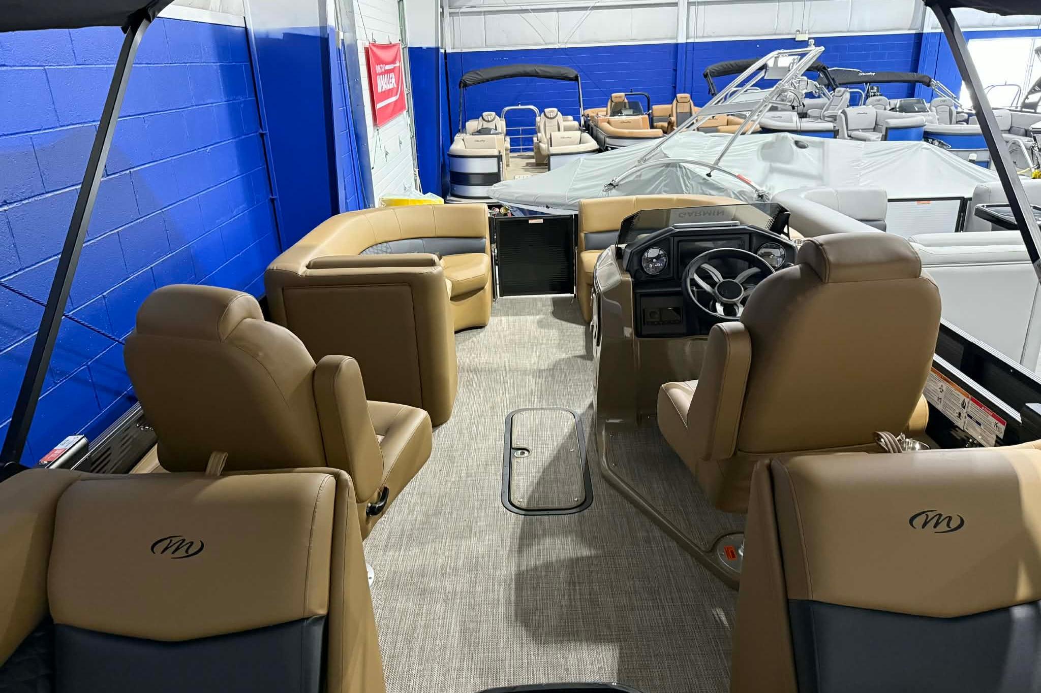 2026 Manitou Encore VP 230 pontoon boat interior with tan seating and steering console.