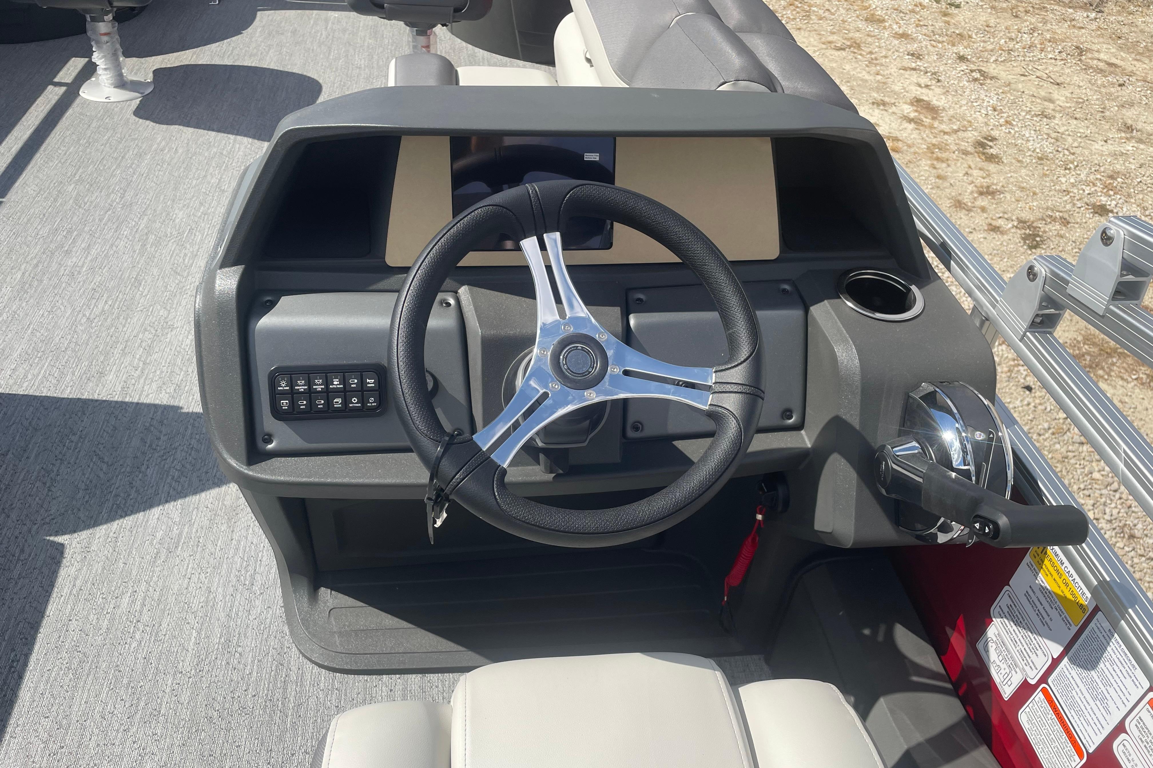 2026 Sun Tracker Fishin' Barge 22 DLX steering console with modern controls and cup holder.