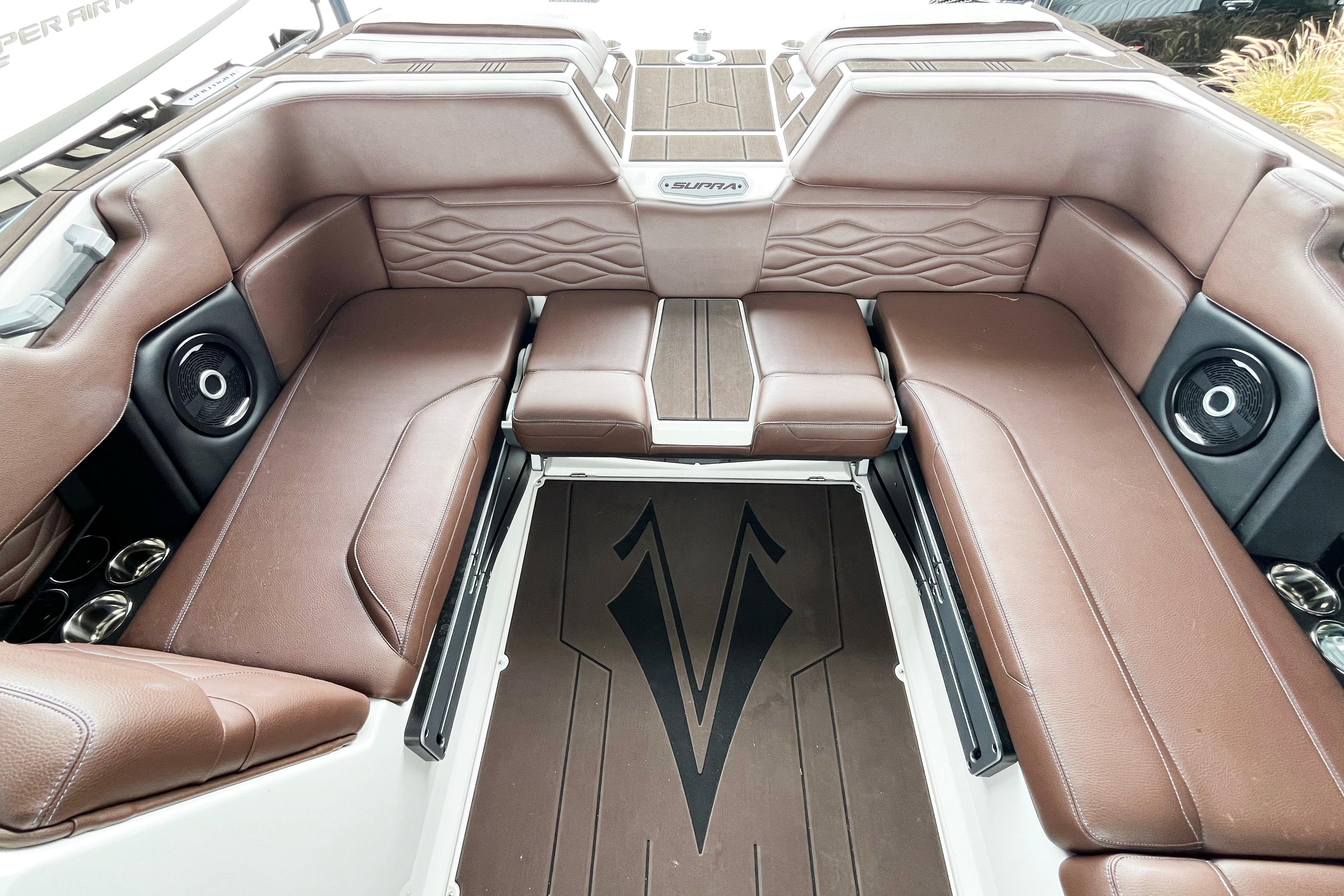 2025 Supra SA450 boat interior with brown leather seating and integrated speakers.