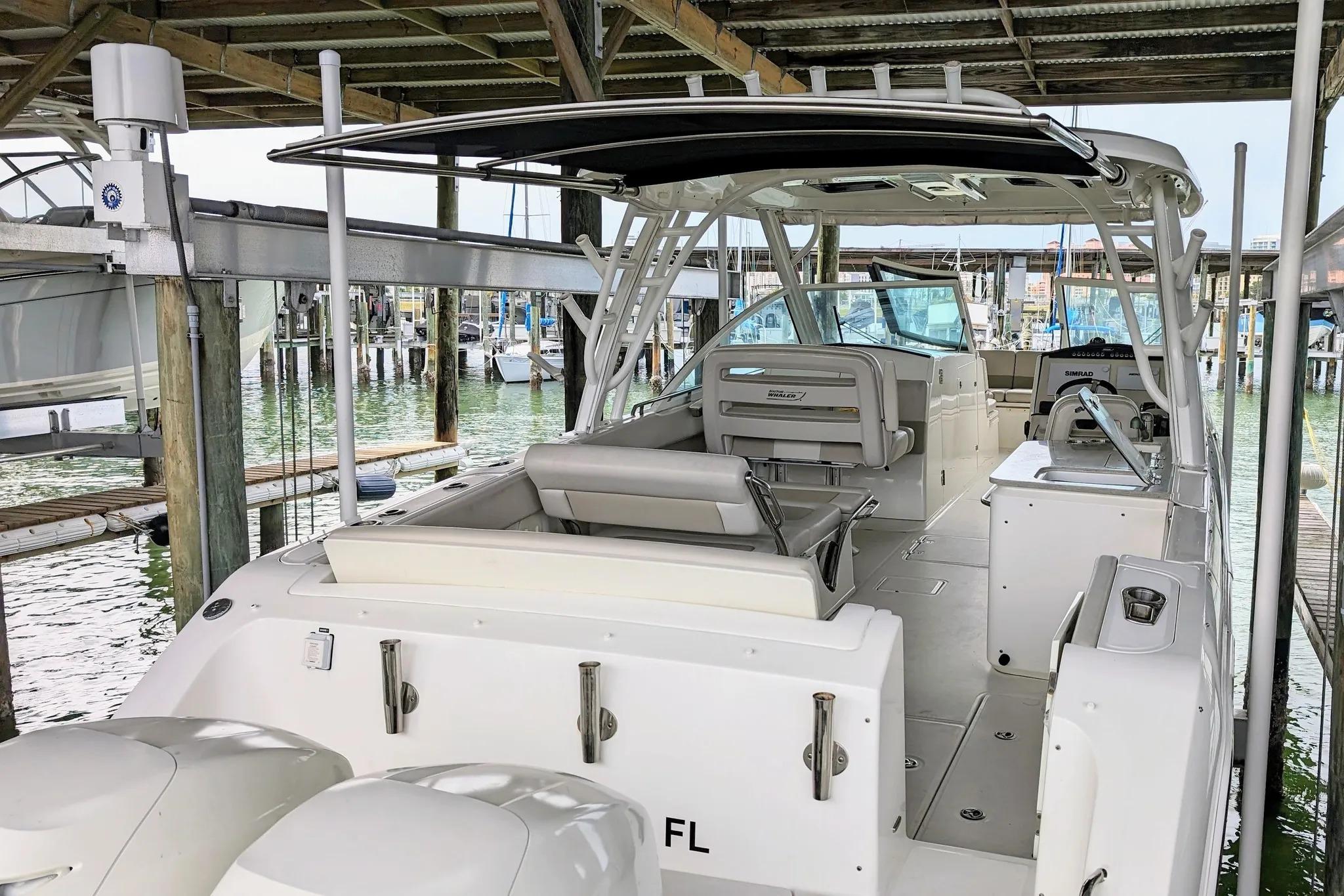 2017 Boston Whaler 320 Vantage docked under shelter, showcasing spacious seating and dual engines.