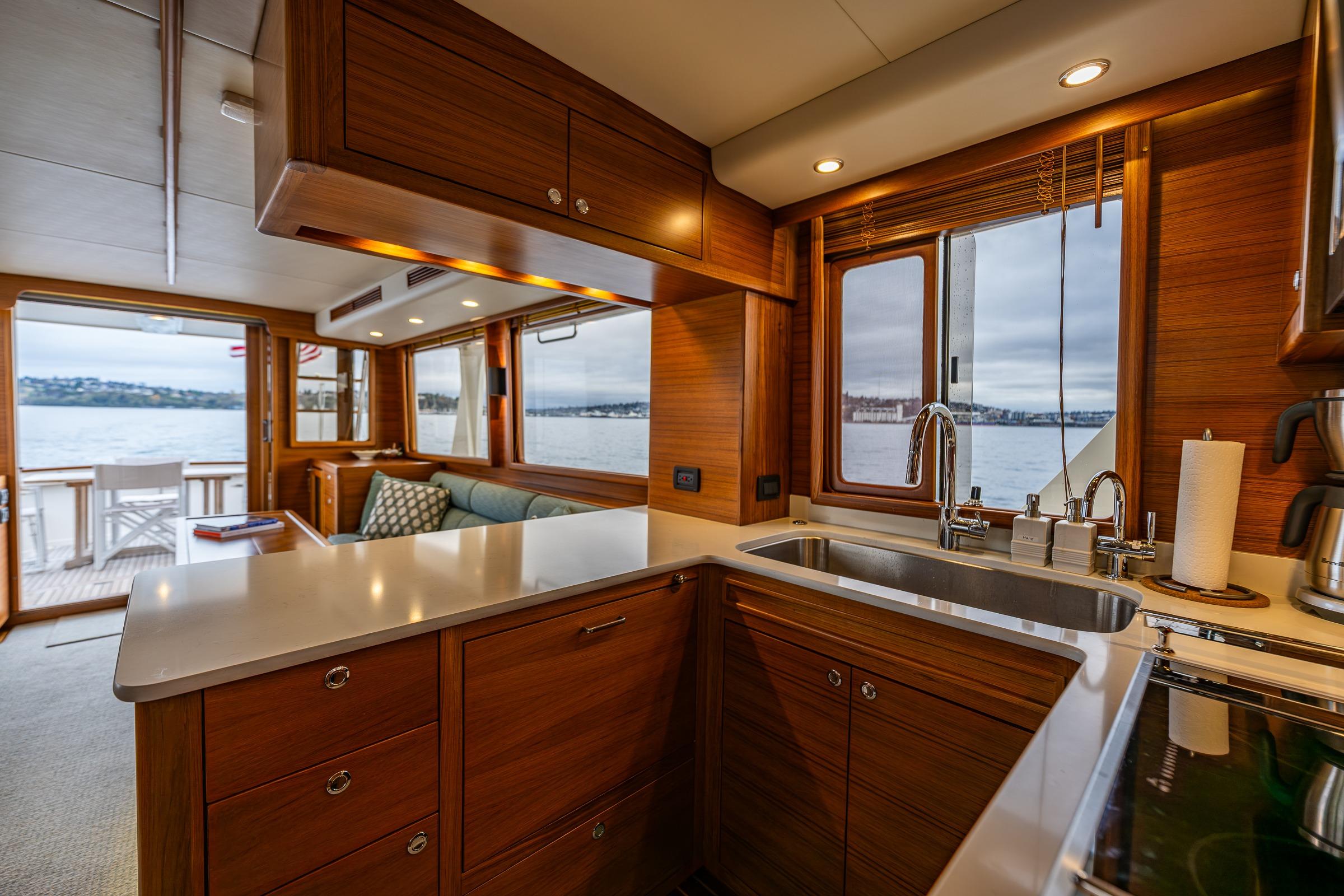 Luxurious 2026 Fleming 55 Pilothouse yacht interior with modern kitchen and scenic water views.