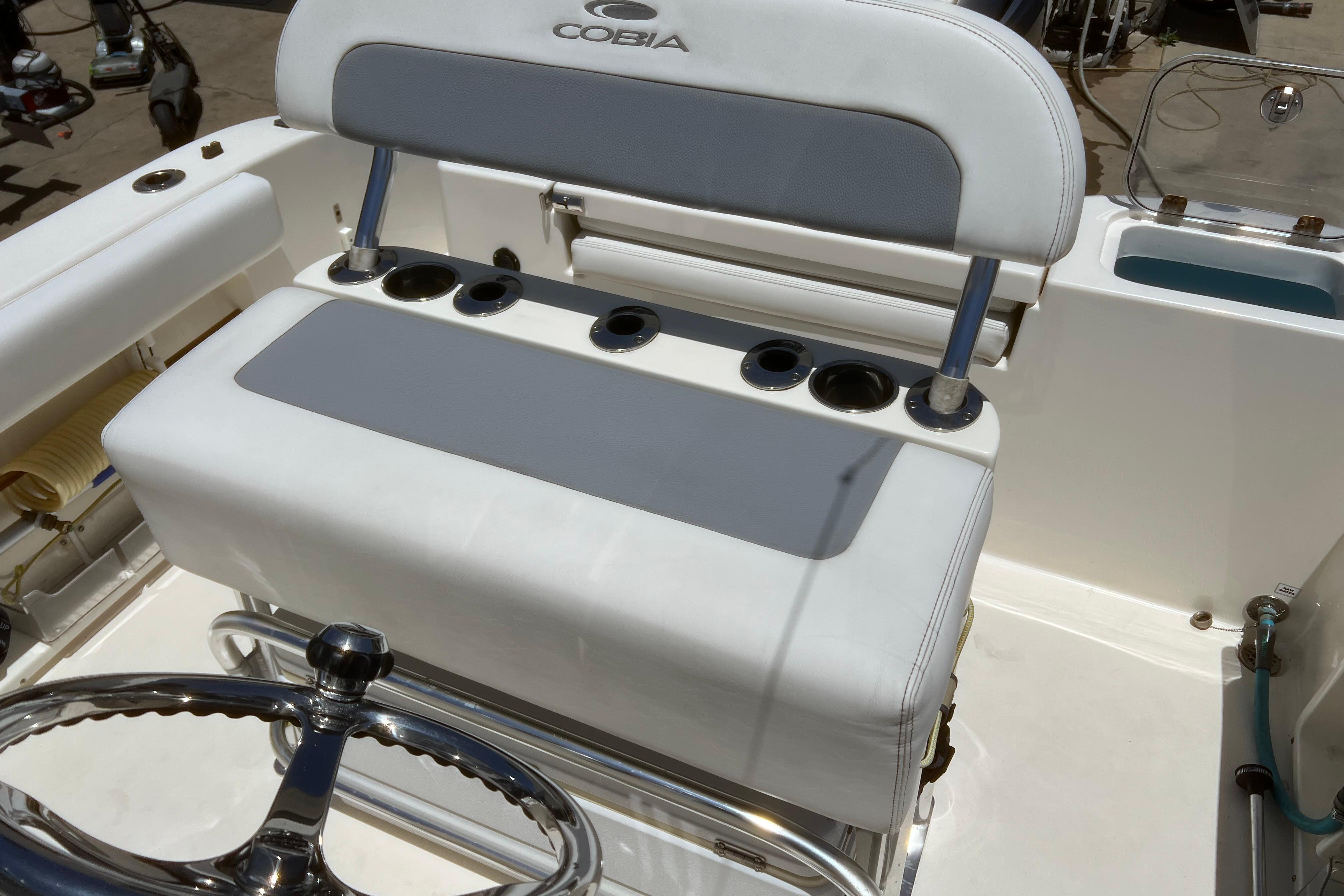 2018 Cobia 201 Center Console boat interior with steering wheel and seating area.