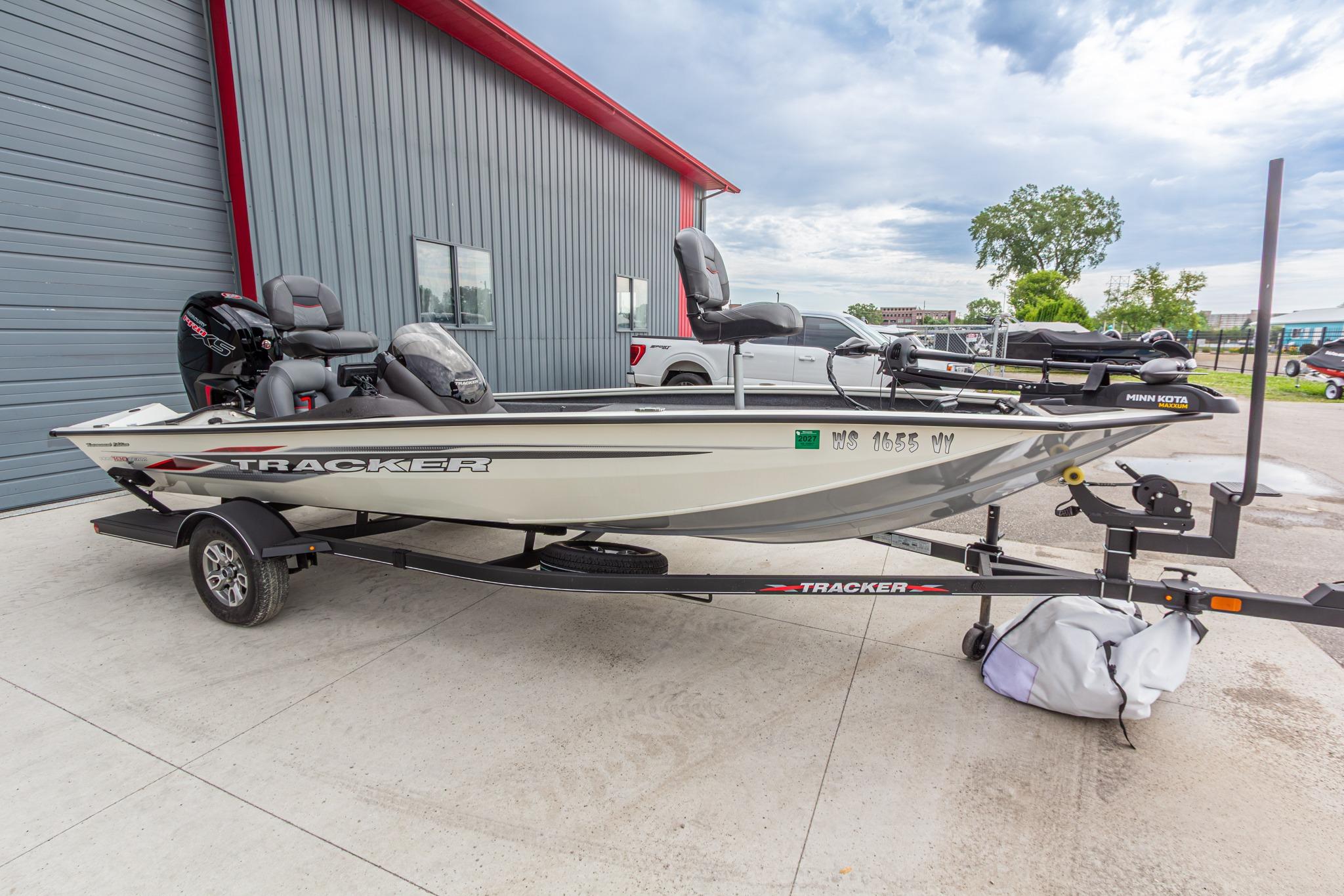 2023 Tracker Pro Team 190 TX fishing boat on trailer, parked outside a building.