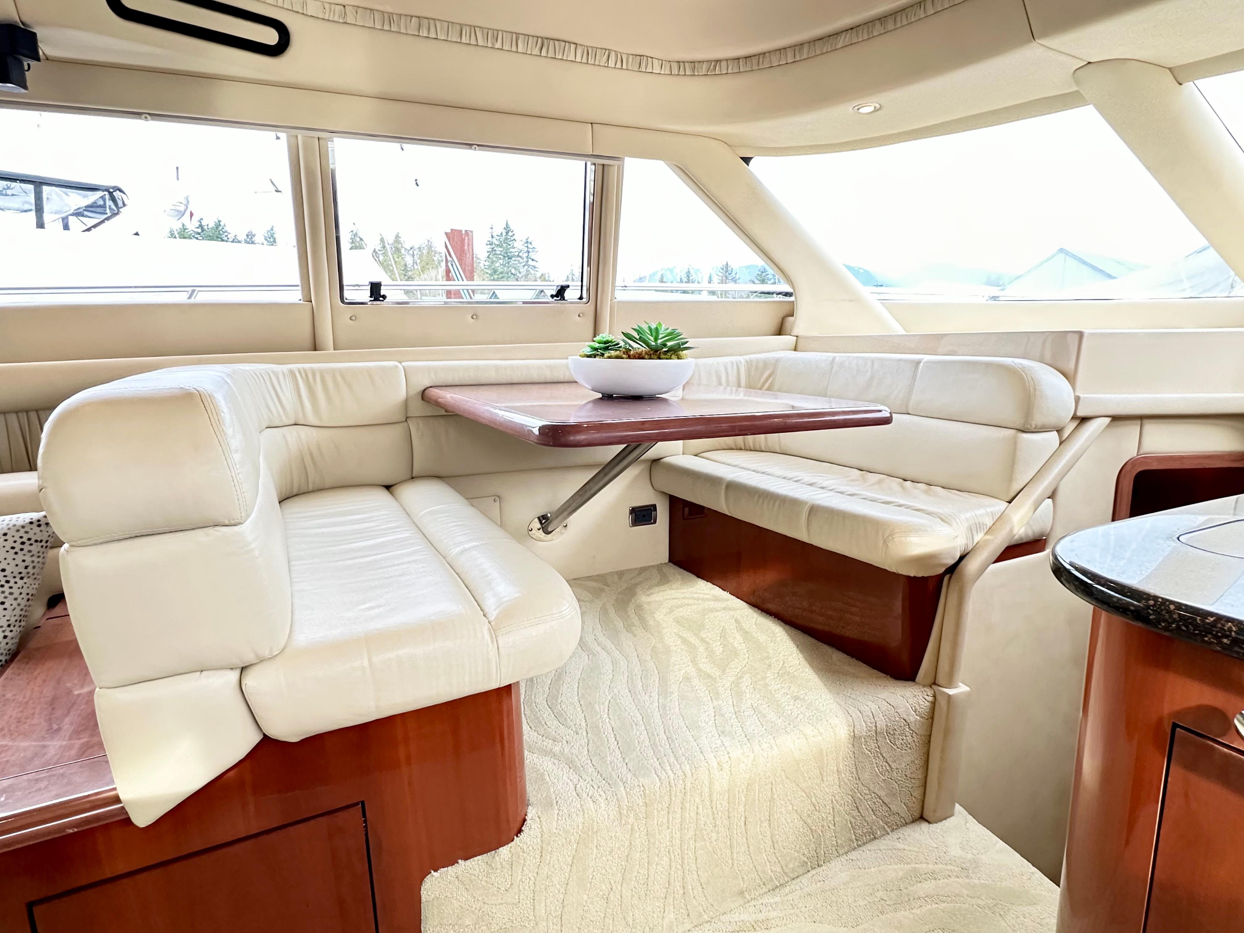 Luxurious interior of 2002 Sea Ray 560 Sedan Bridge with plush seating and elegant table.