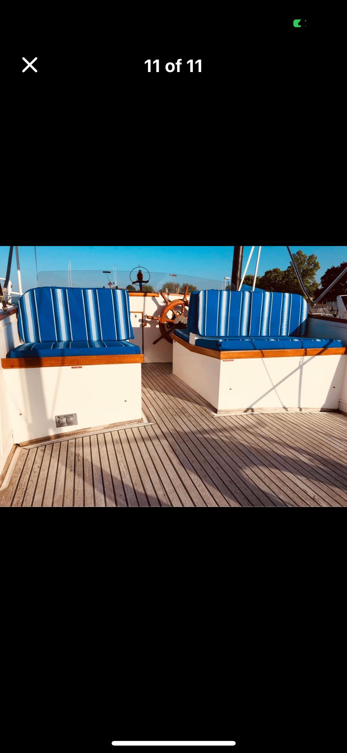 1978 Grand Banks 36 Classic boat deck with blue-striped seating and wooden flooring.