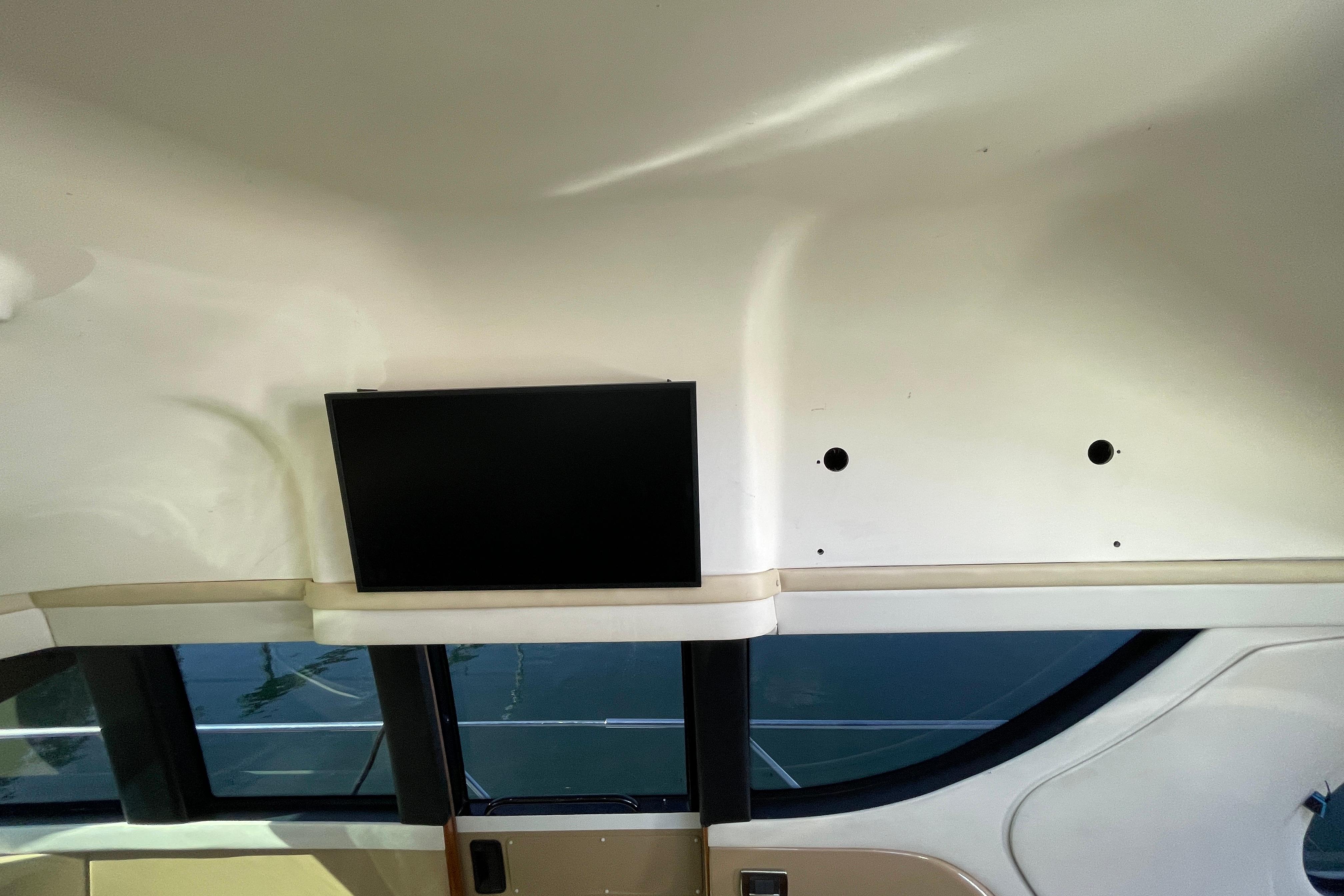 Interior of 2002 Carver 570 Voyager Pilothouse with mounted TV and windows.