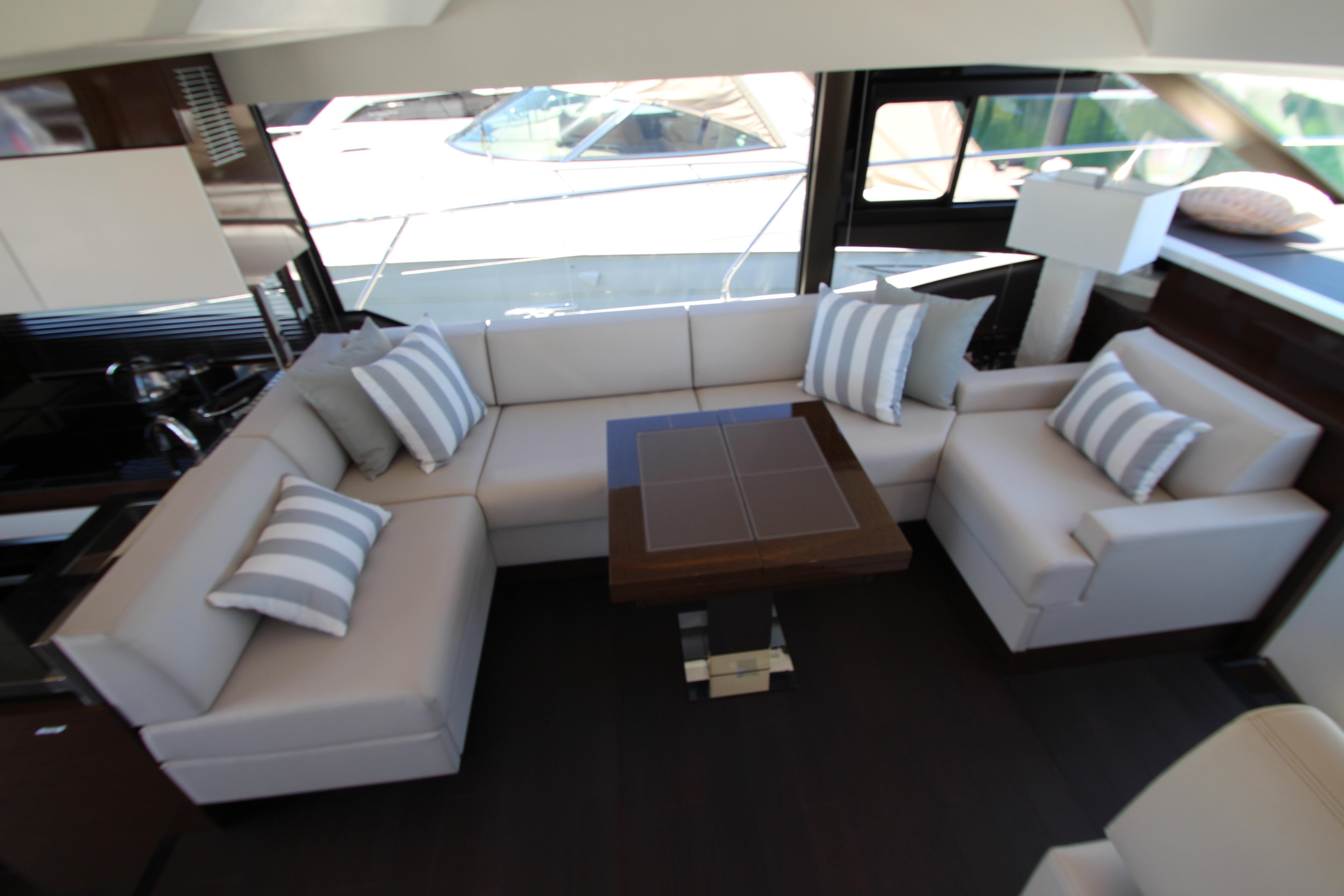 Luxurious interior of 2022 Prestige 520 yacht with elegant seating and striped cushions.