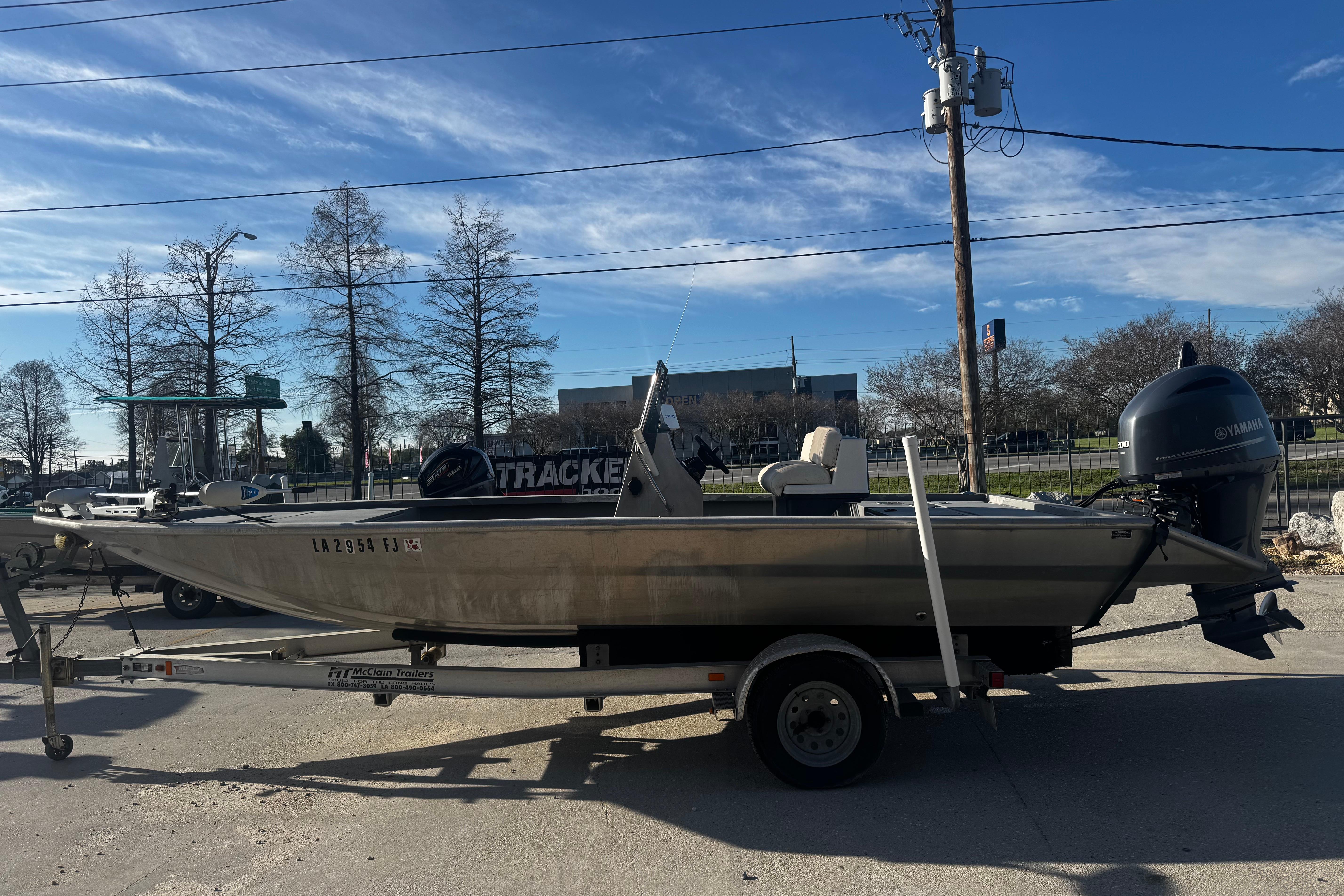Custom Charles Leonard 21 boat on trailer, parked outdoors, clear sky background.