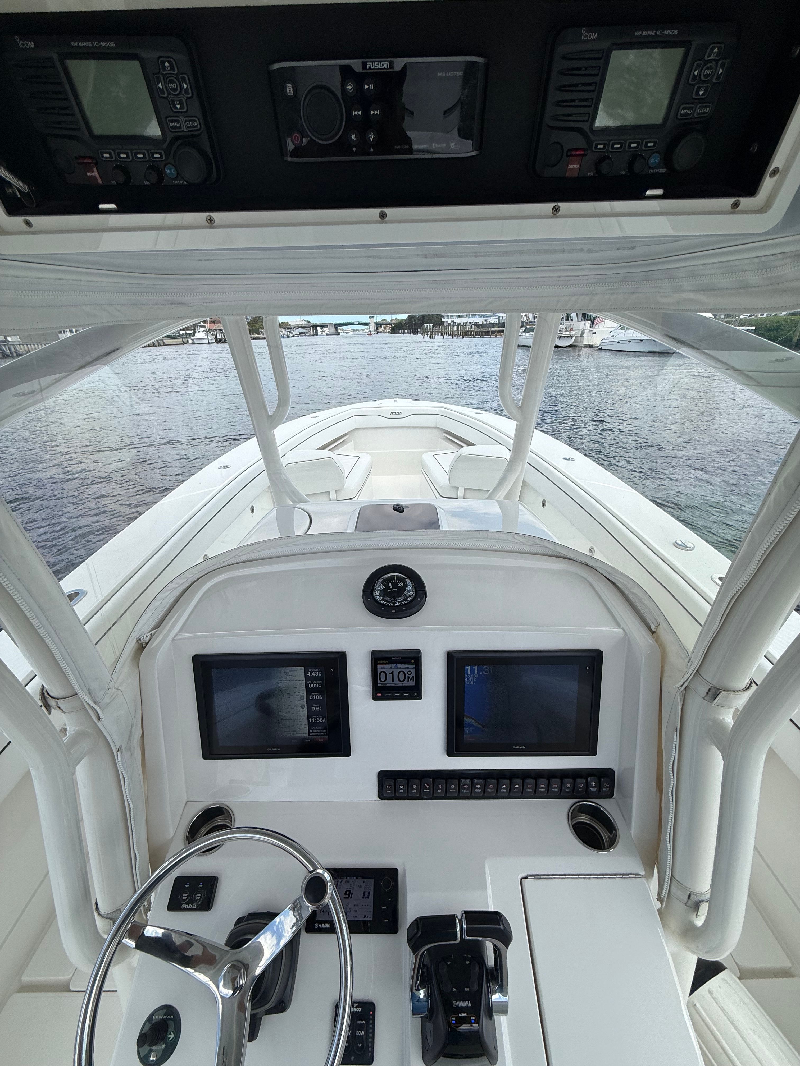 Interior view of 2015 Jupiter 34 FS boat cockpit with controls and screens.