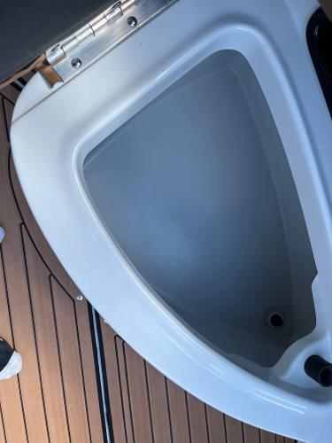 2024 Crownline Eclipse E255 boat storage compartment with teak flooring.