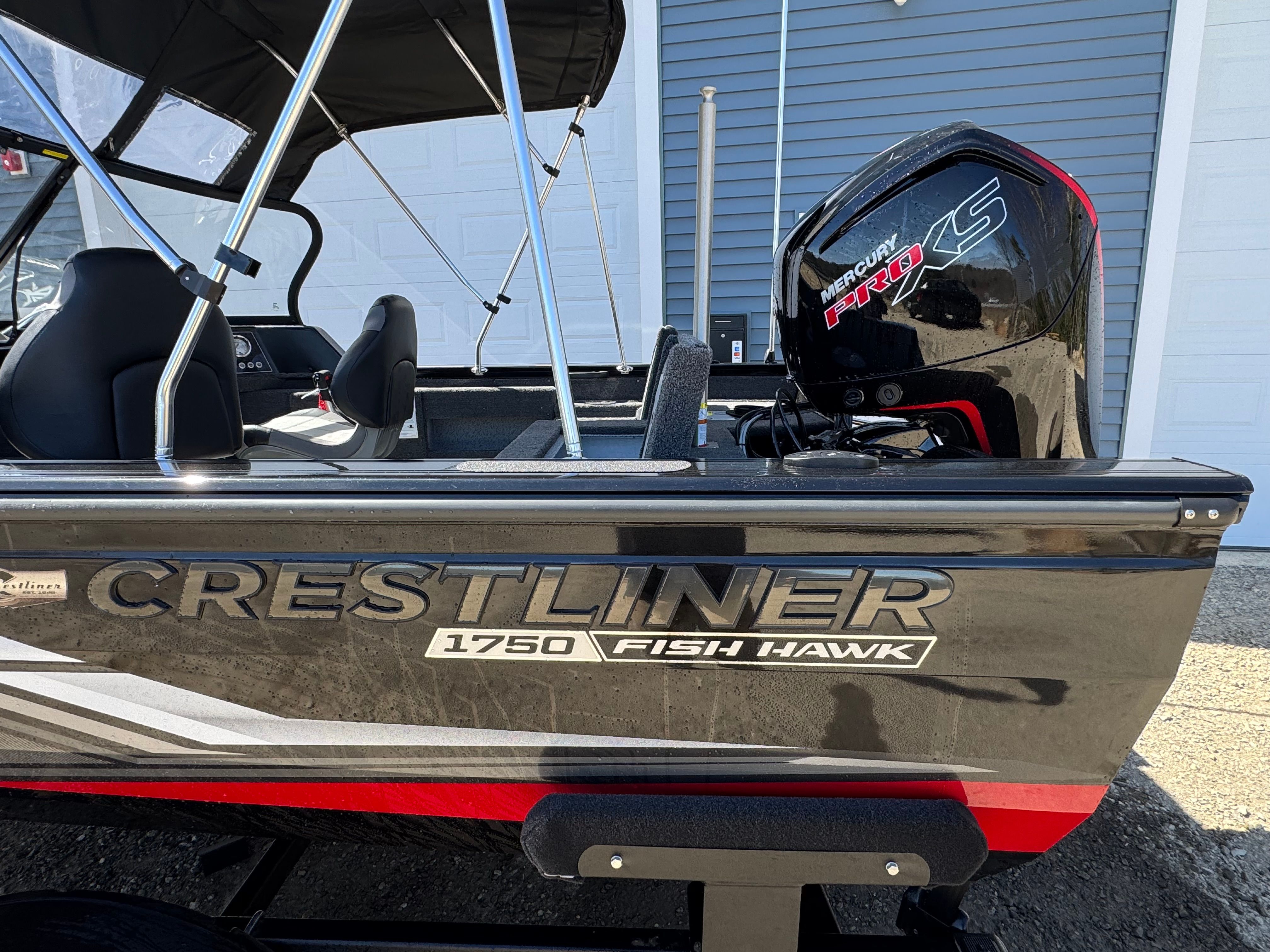 A Crestliner 1750 Fish Hawk WT boat with a Mercury engine.