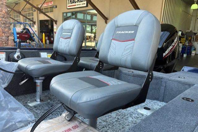 2026 Tracker Pro Guide V-16 SC boat seats in showroom, featuring gray upholstery and modern design.