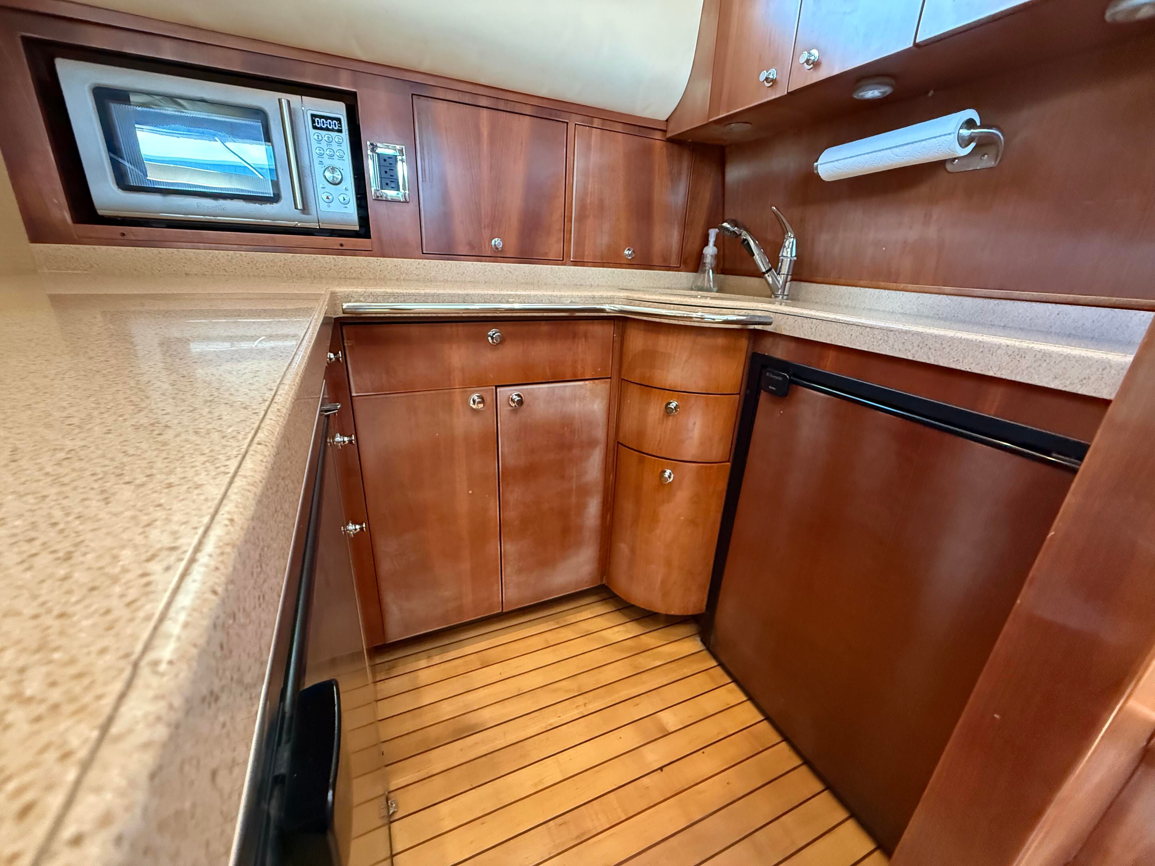 Galley of the 2007 Chris-Craft Roamer 40 with wood cabinets, microwave, and fridge.