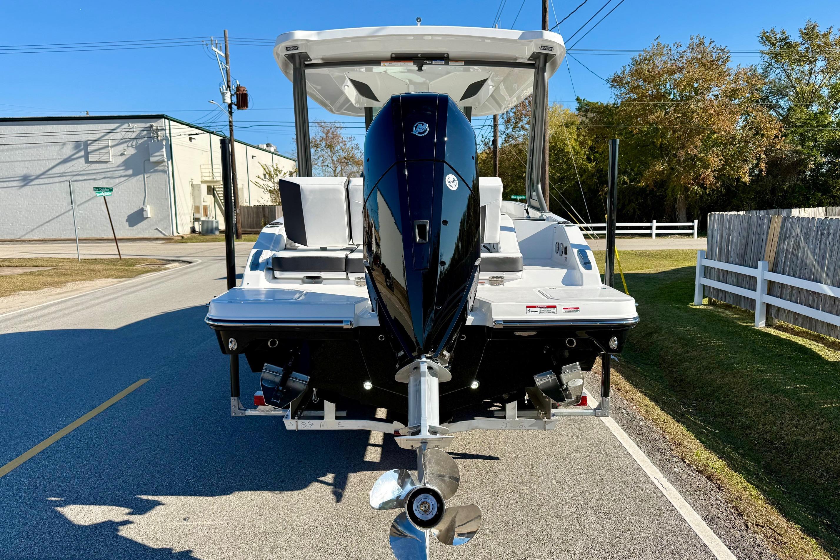 2026 Monterey Elite 27 OB with outboard motor on road.