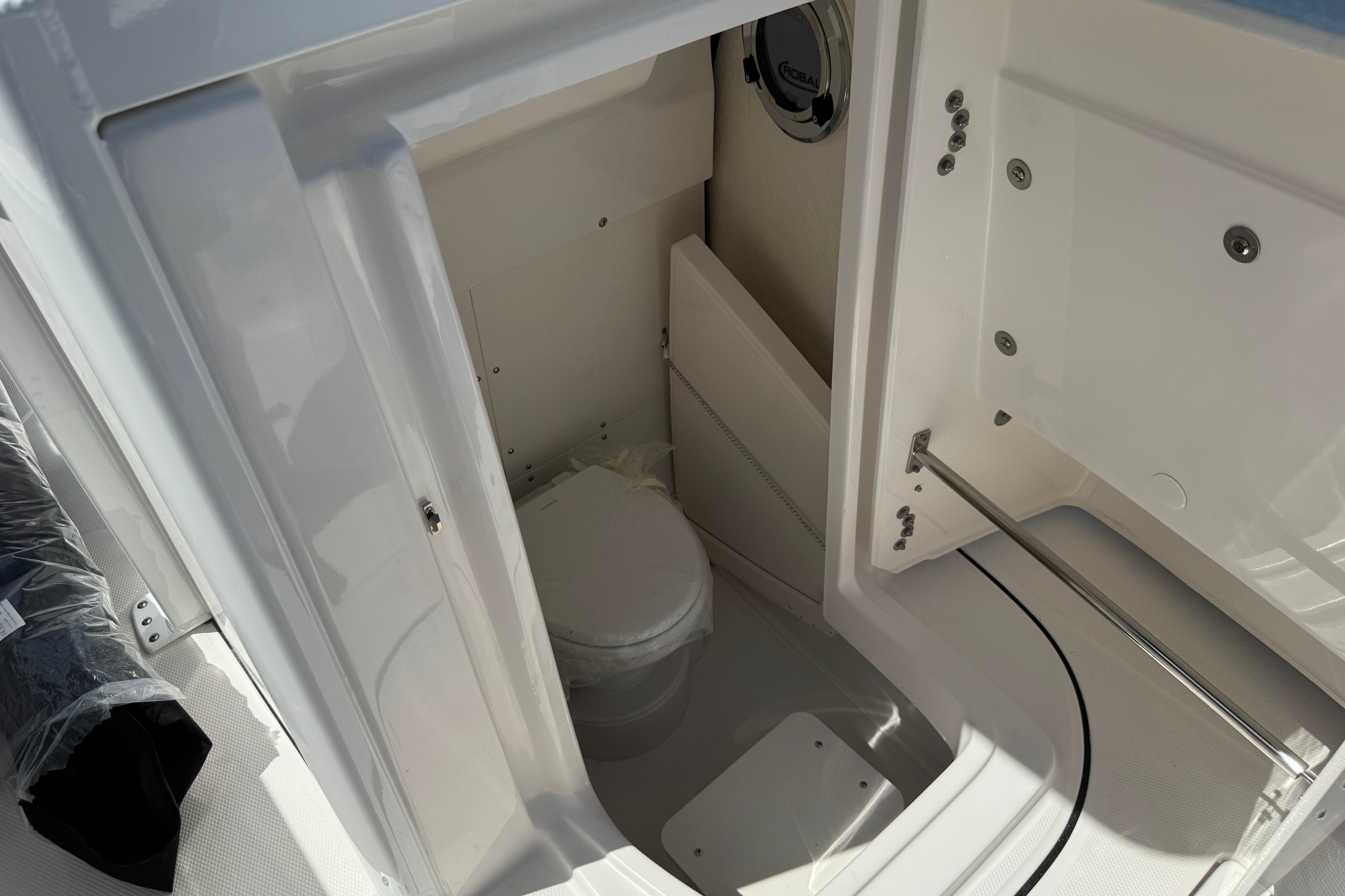 2026 Robalo R250 Center Console boat interior with compact marine toilet.