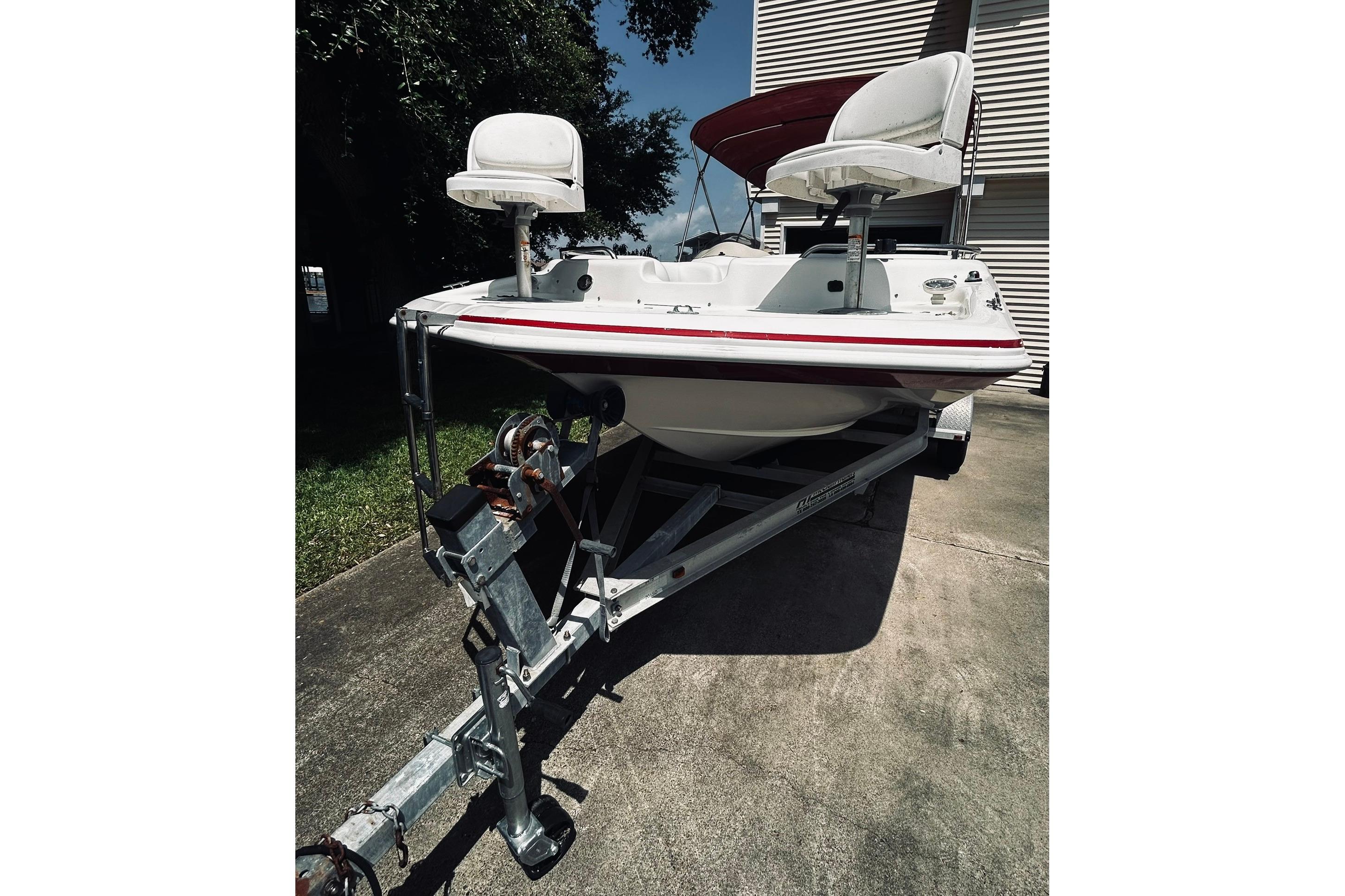 2013 Hurricane SunDeck Sport 201 OB boat on trailer, parked outdoors.