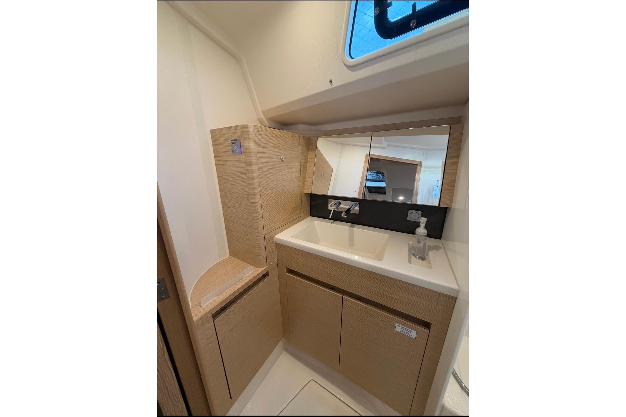 Modern bathroom interior of 2022 Hanse 418 yacht with sleek fixtures and wooden cabinetry.