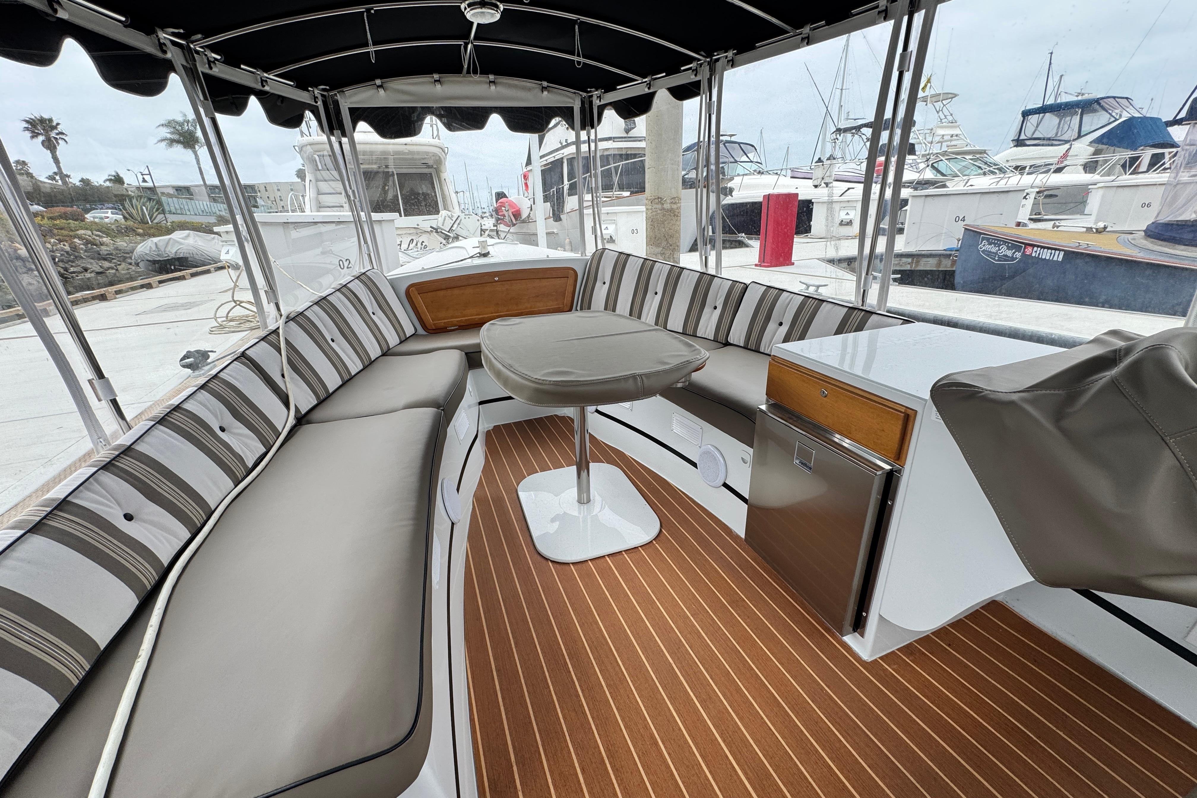 Interior of 2023 Duffy Bay Cruiser with striped seating and wood-style flooring at a marina.