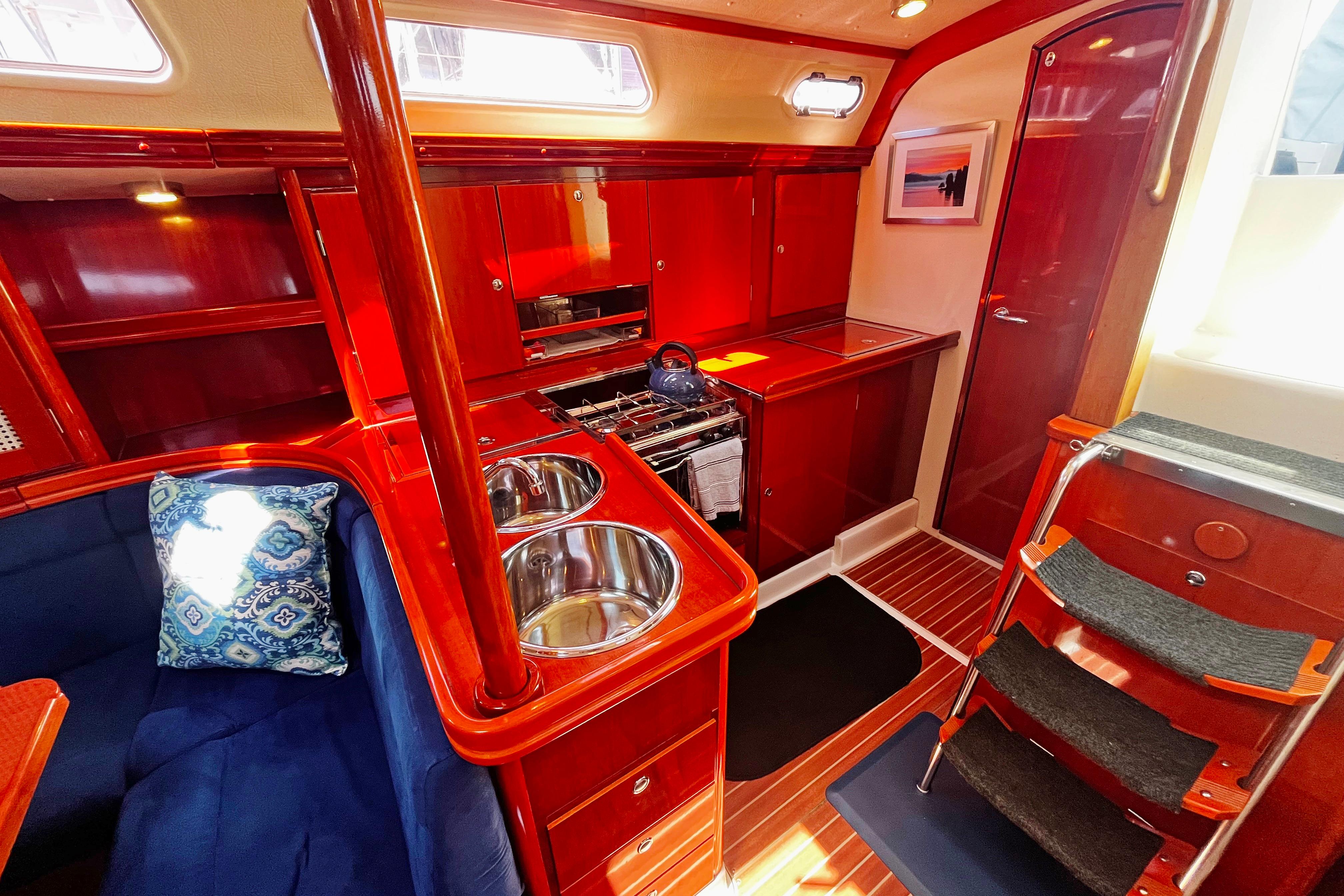 Luxurious 2004 Hanse 411 yacht interior with polished wood, dual sinks, and cozy seating.