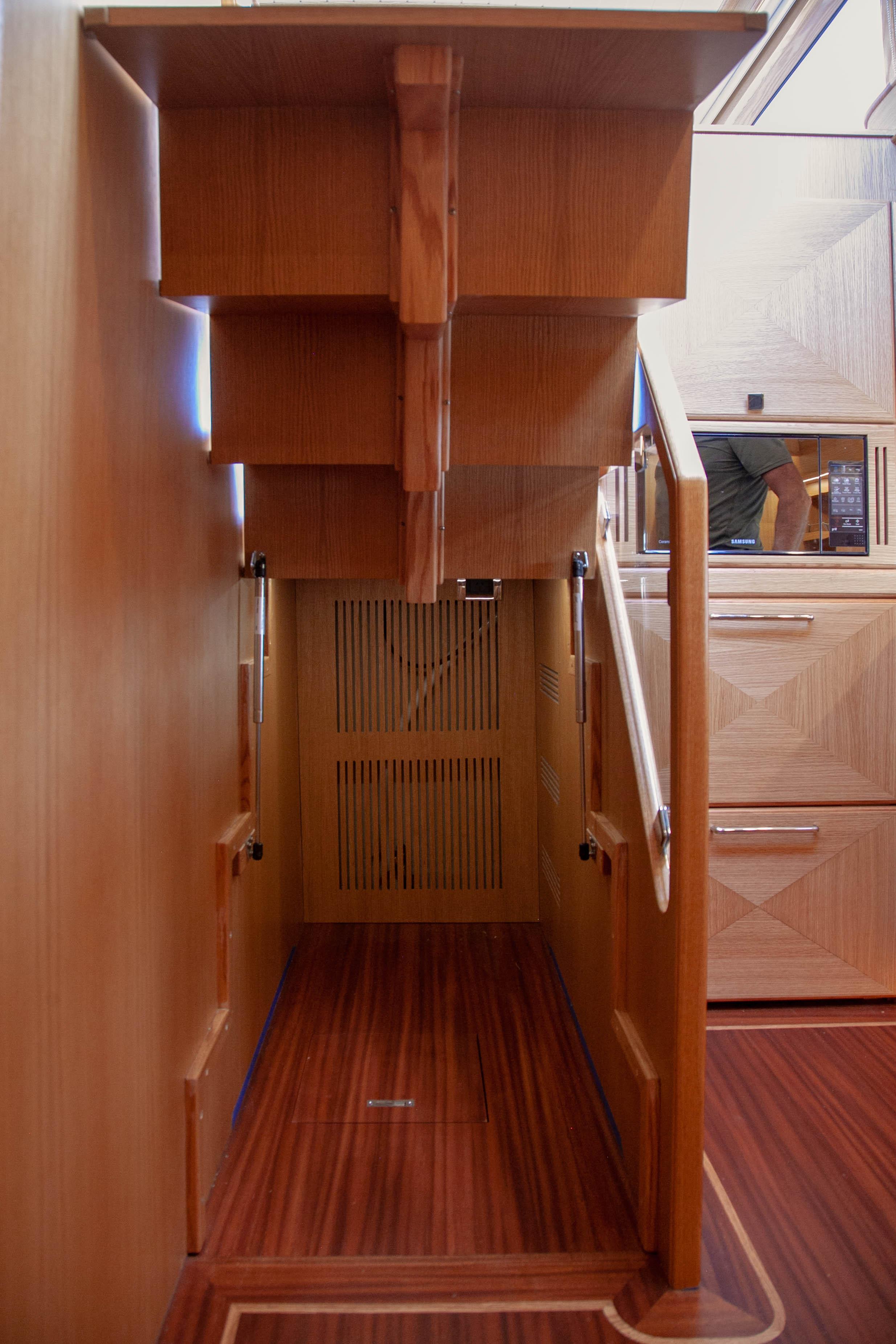 Interior of 2023 Vicem 55 yacht, featuring wooden stairs and elegant cabinetry.