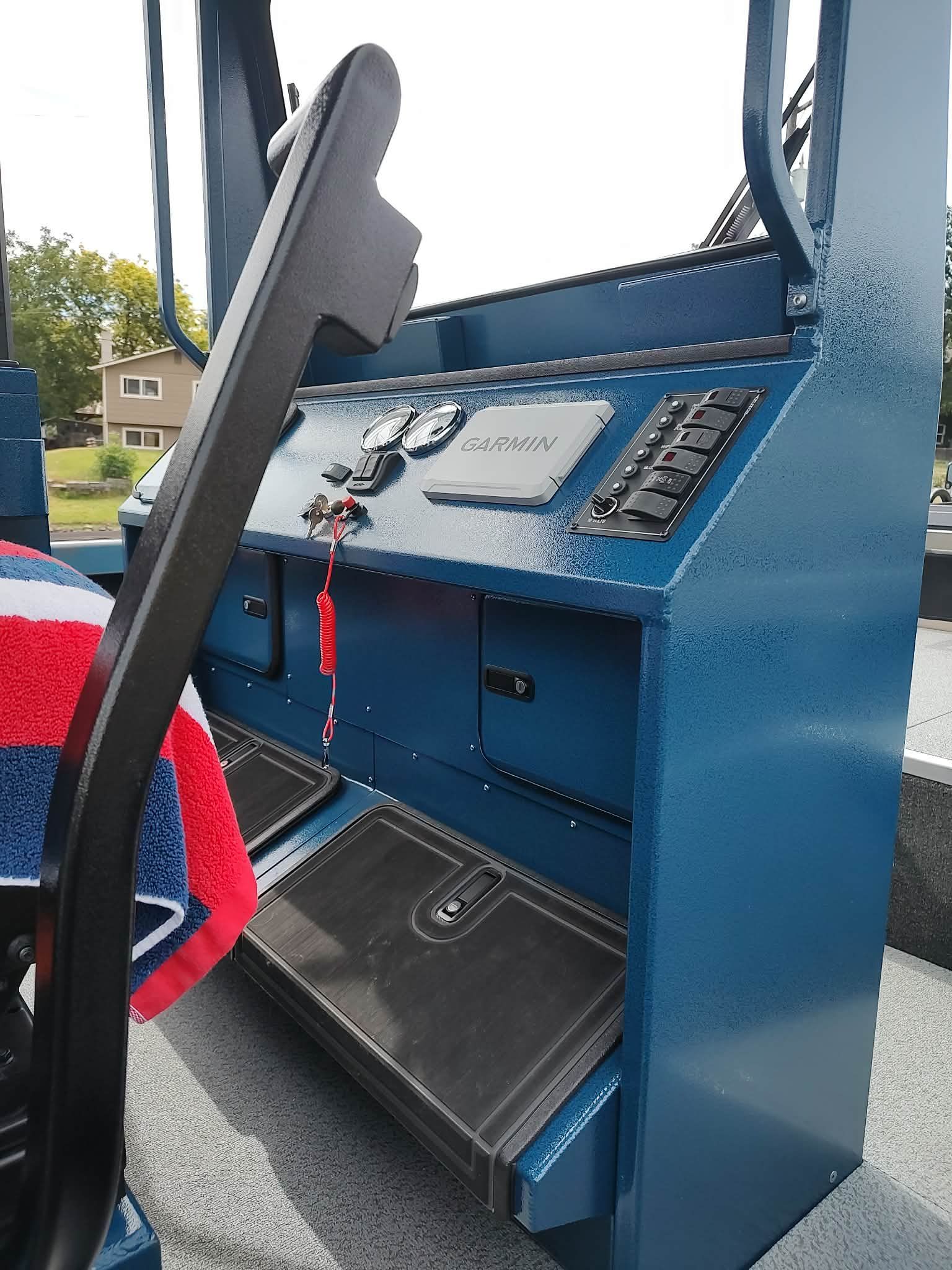 The image shows the helm of a Custom Weld 23' sled t-top boat with Garmin equipment.