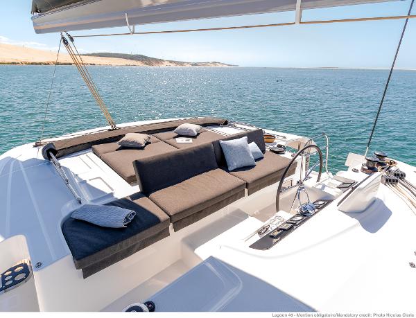 Luxurious Lagoon 46 ICONIC yacht deck with plush seating, overlooking serene ocean waters, 2025 model.