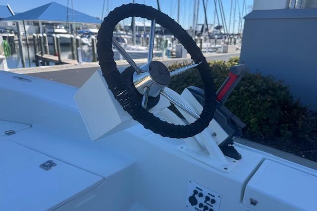 Steering wheel of 2024 Rigid Boats 10 Sport at marina, showcasing sleek design.