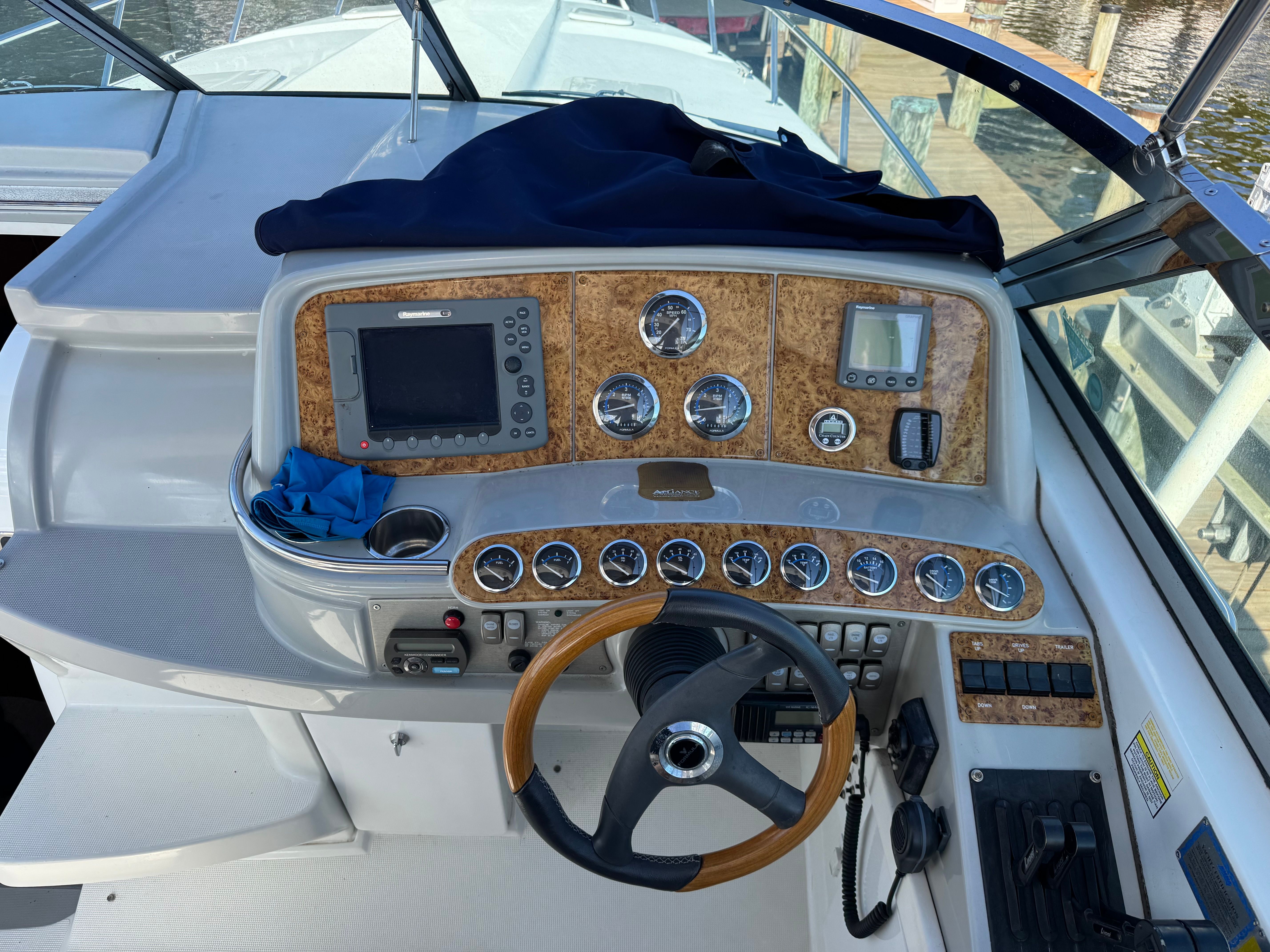 The cockpit of a boat with wood paneling and numerous instruments.