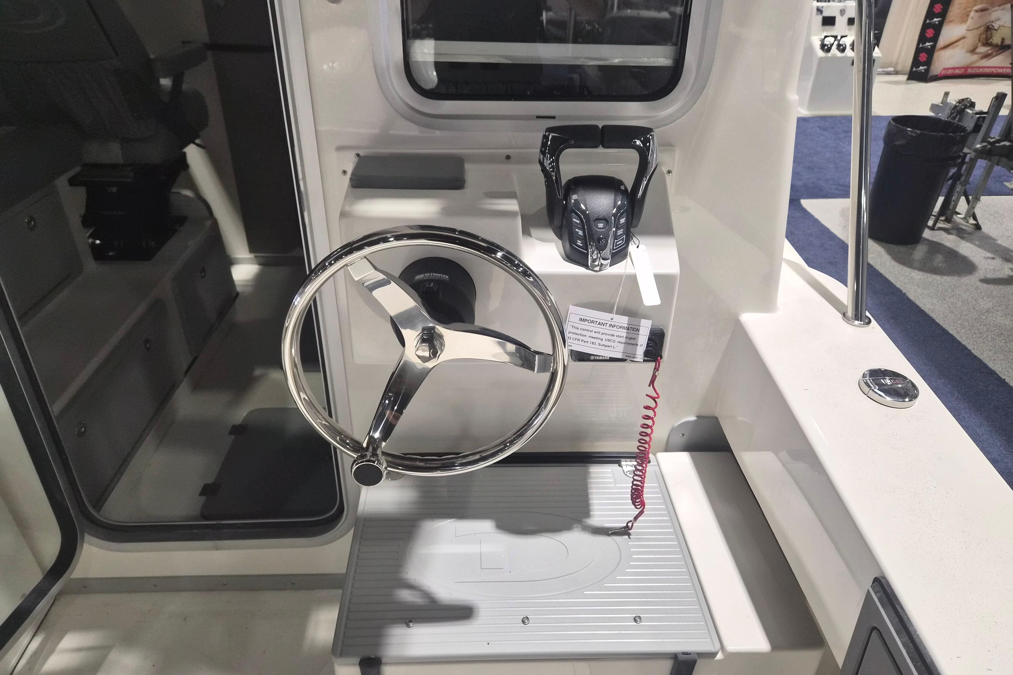 Helm of 2026 Defiance Admiral 260 EX boat with steering wheel and controls.