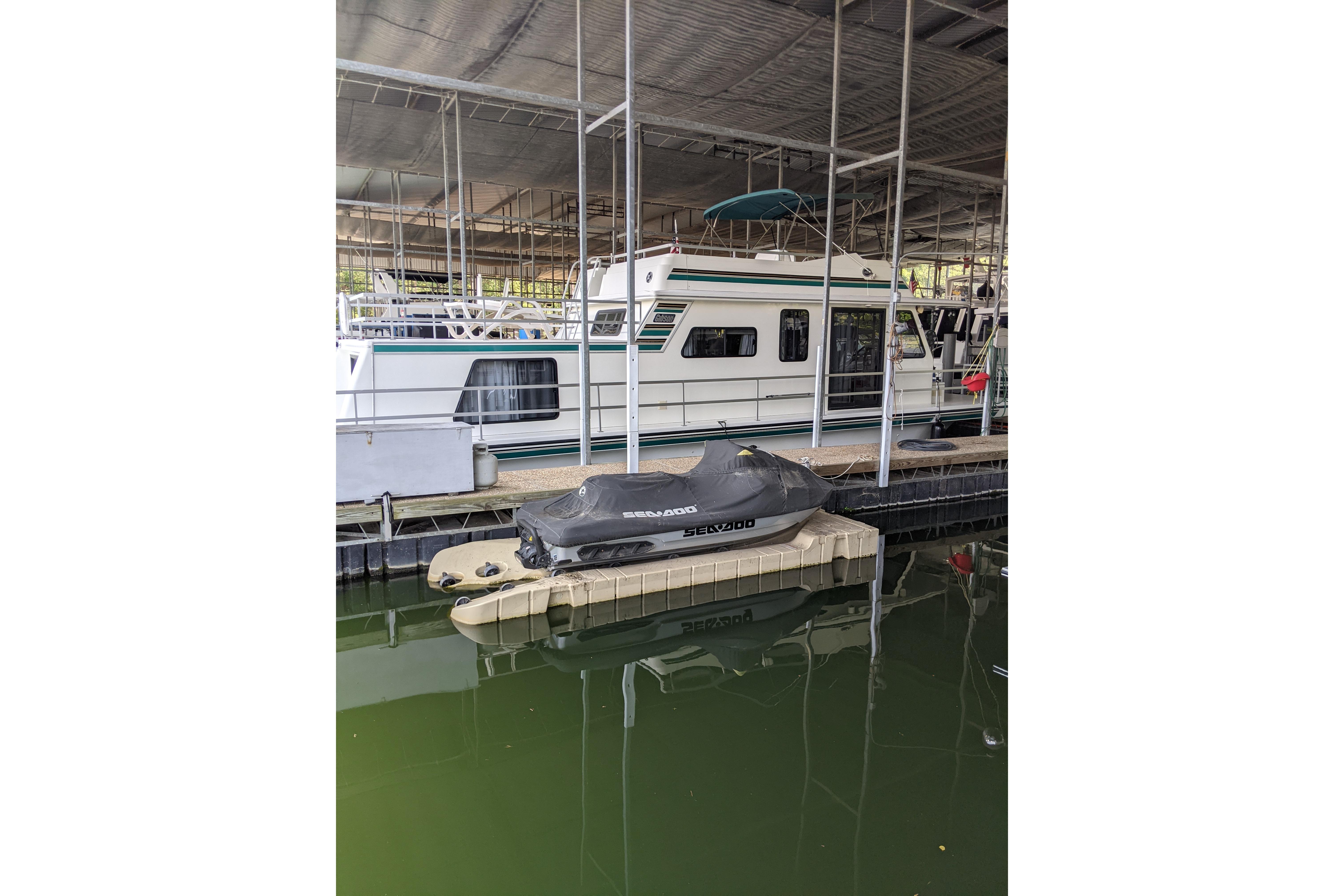 2001 Gibson 50 Cabin Yacht docked with covered jet ski nearby.
