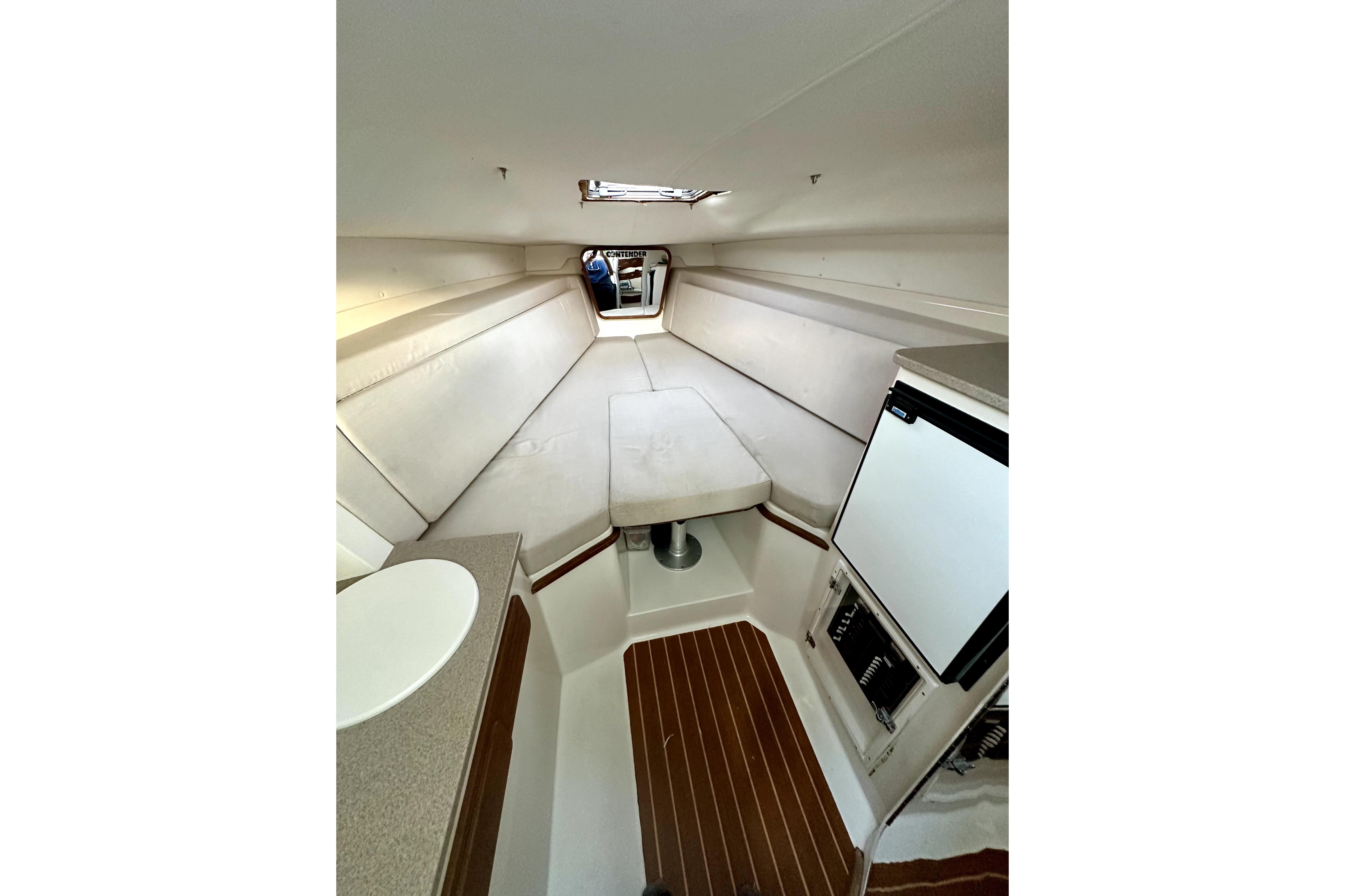 Interior of 2006 Contender 35 Express Side Console with seating, table, and kitchenette.