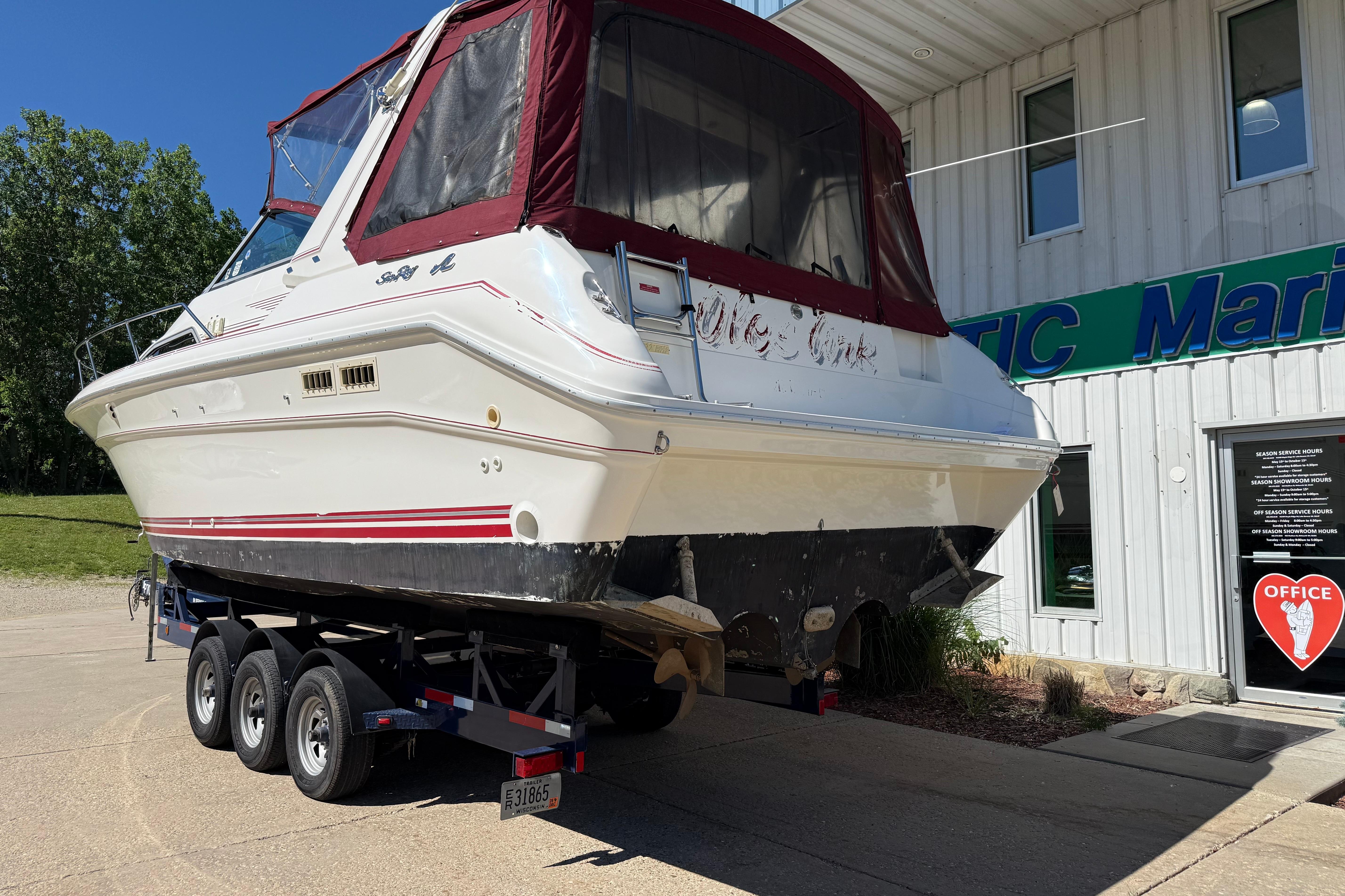 1990 Sea Ray 310 Express Cruiser on trailer outside marine office.