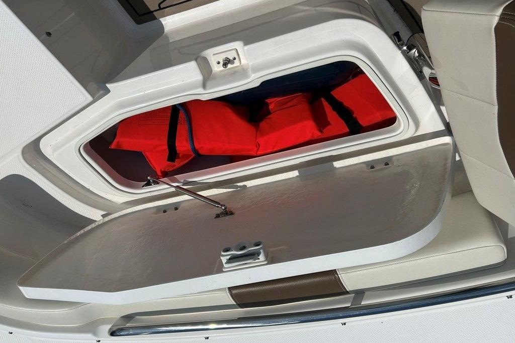 2017 Robalo R200ES boat storage compartment with red life jackets inside.