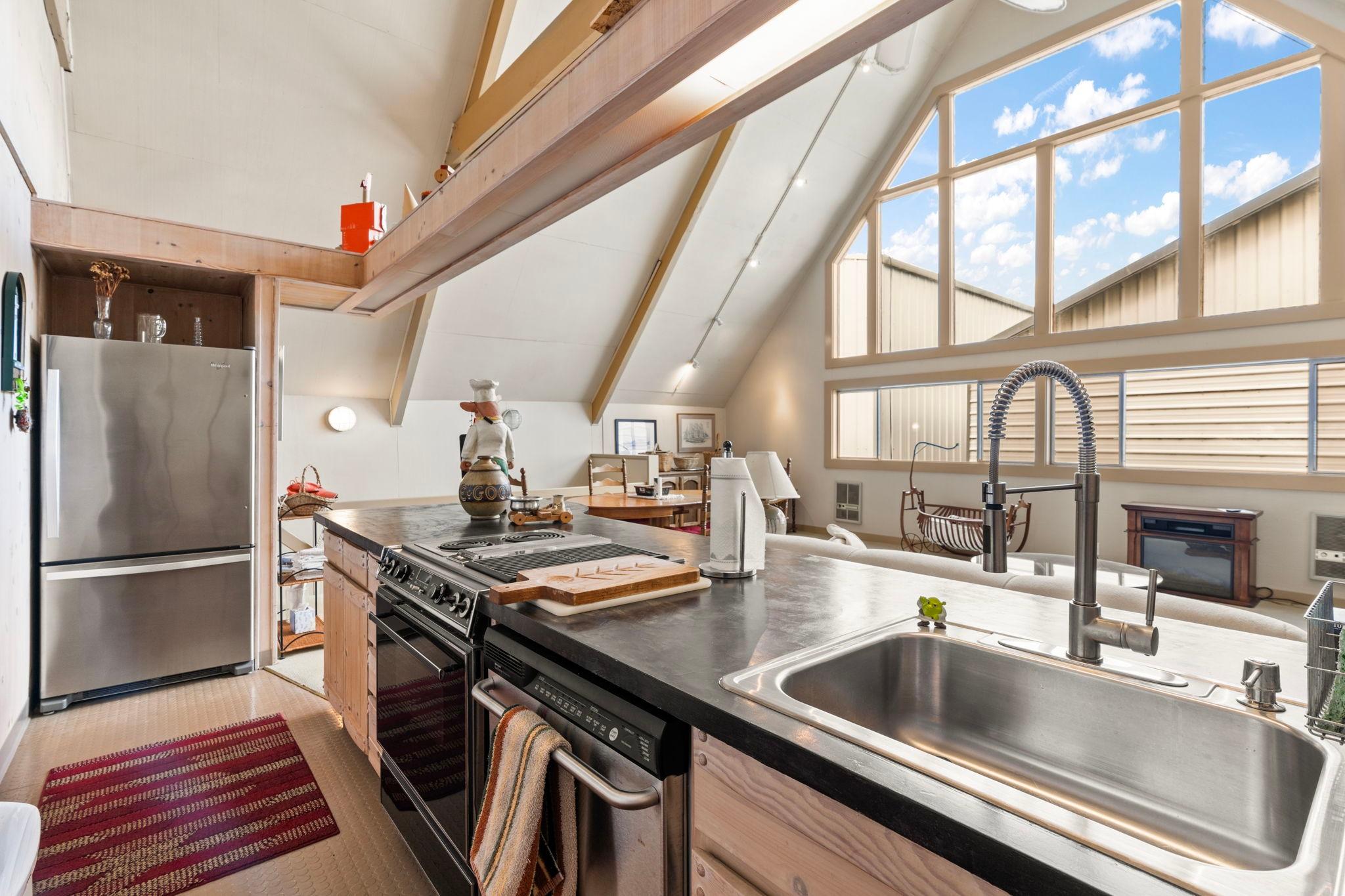 Modern kitchen in a 1976 custom boathouse with vaulted ceilings and large windows.