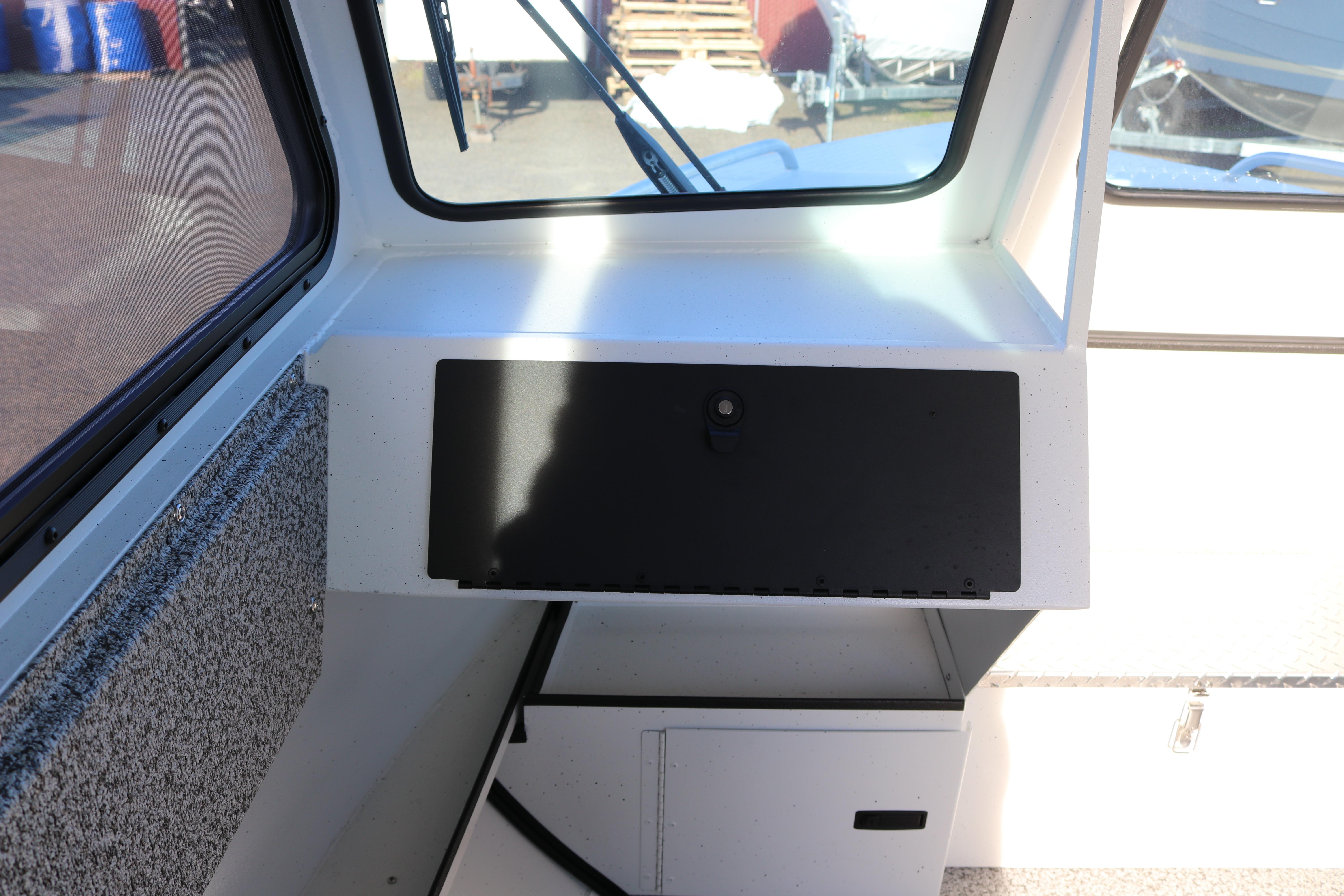 Interior view of 2026 Alumaweld Intruder Outboard 22 boat, featuring dashboard and storage compartment.