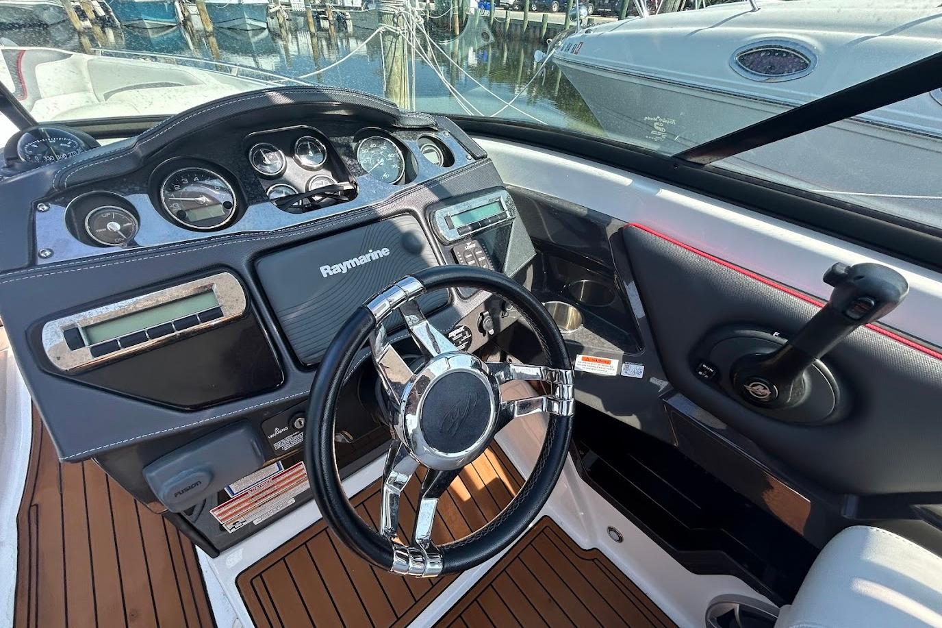 2015 Monterey 288 Super Sport dashboard with Raymarine navigation and sleek steering wheel.