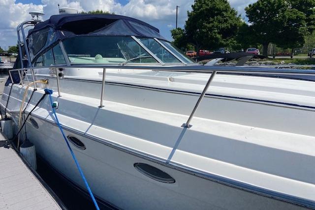 1994 Cruisers Yachts 3675 Esprit docked, featuring sleek design and blue canopy.