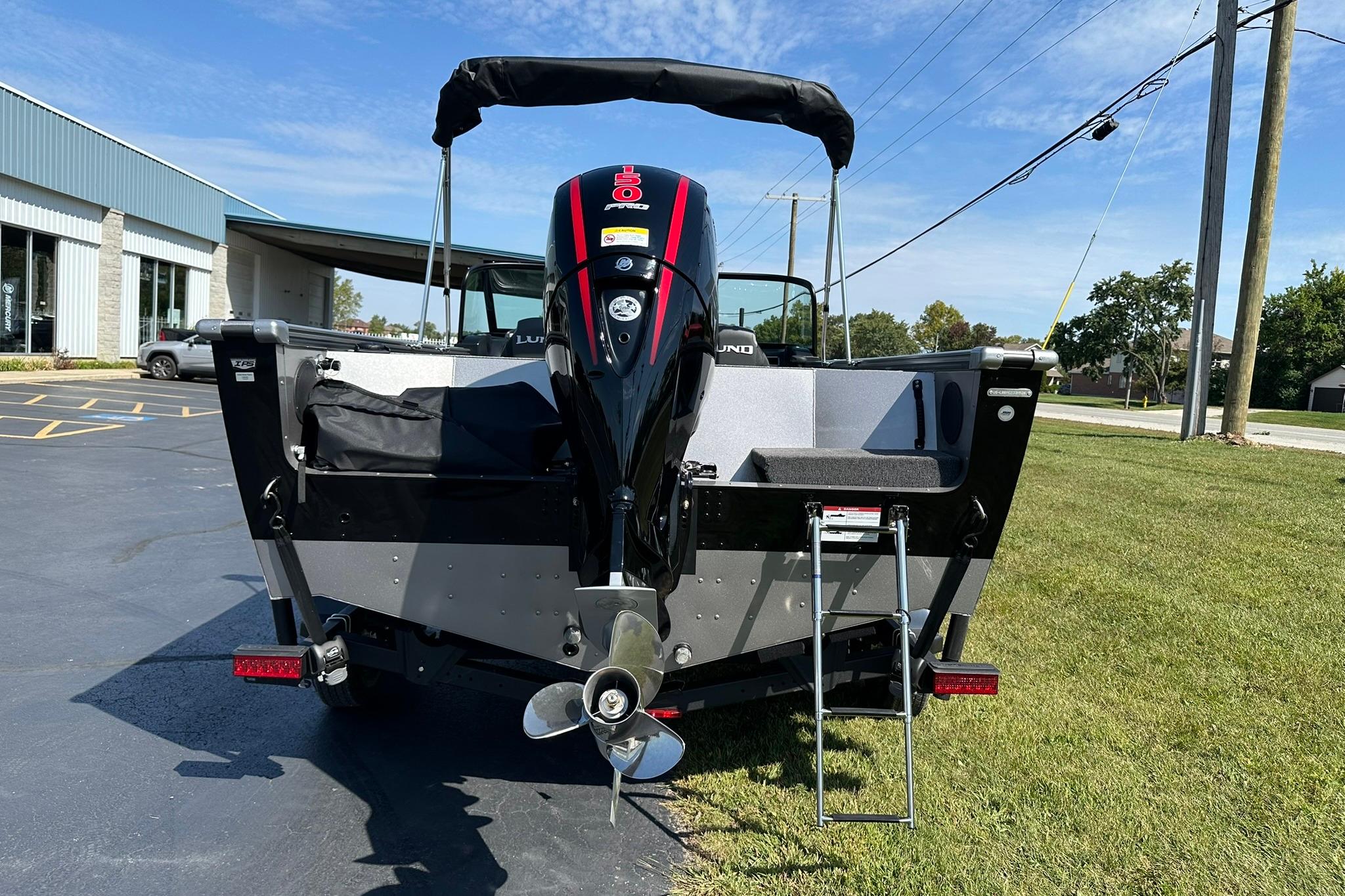 2026 Lund 1875 Fisherman boat rear view with outboard motor and ladder.