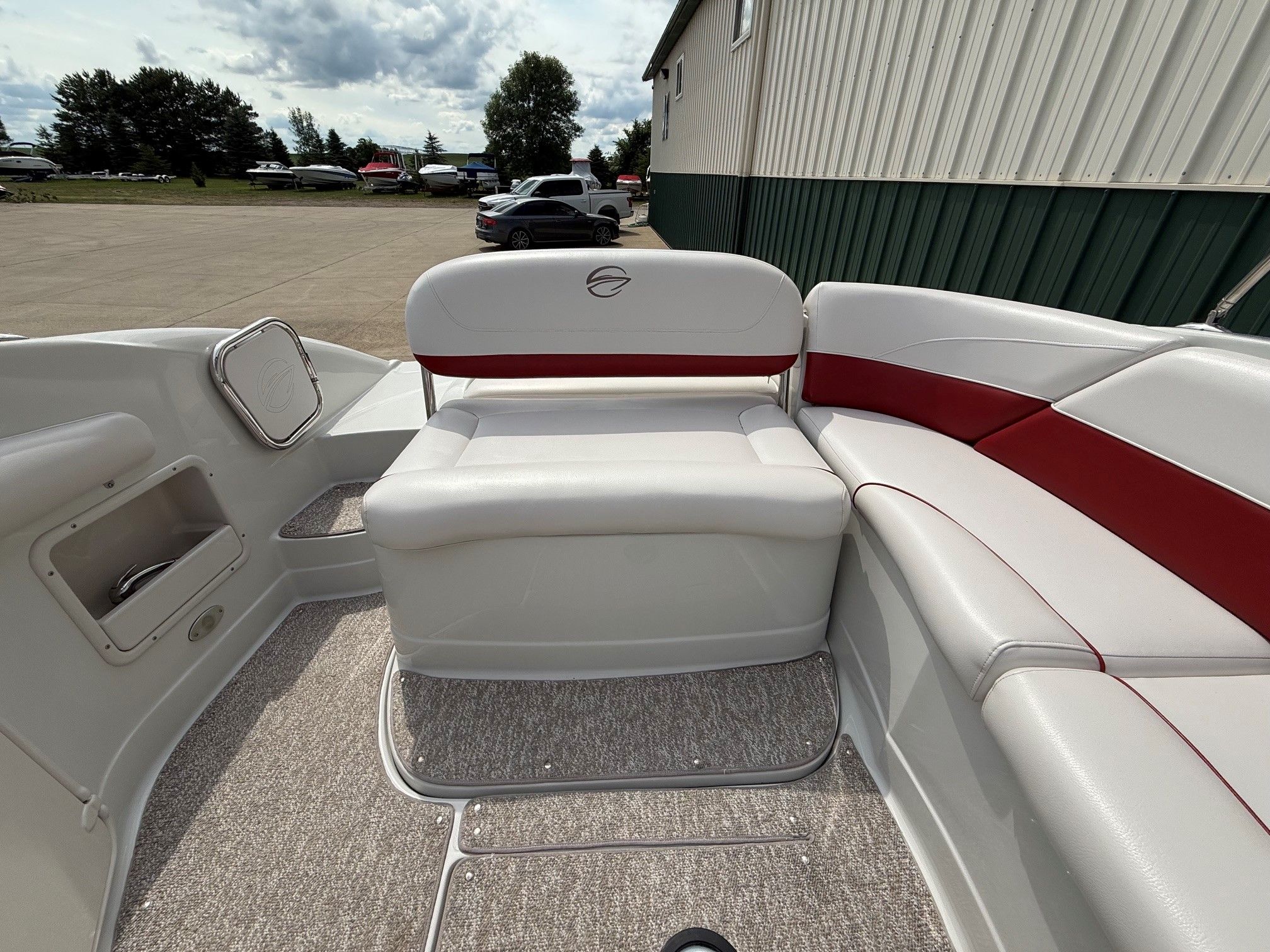 The image shows the cockpit of a 2012 Crownline 252 EX boat with white and red seating.