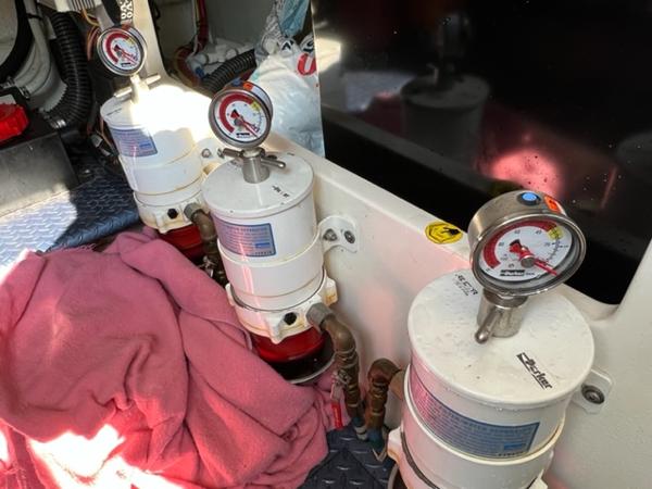 Fuel filters and pressure gauges in the engine room of a 2009 Ovation 52 boat.