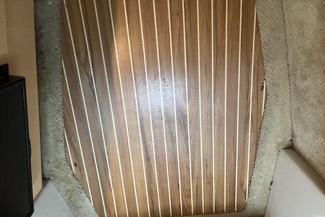 Wooden floor panel on 2012 Bayliner 285 Cruiser boat interior.