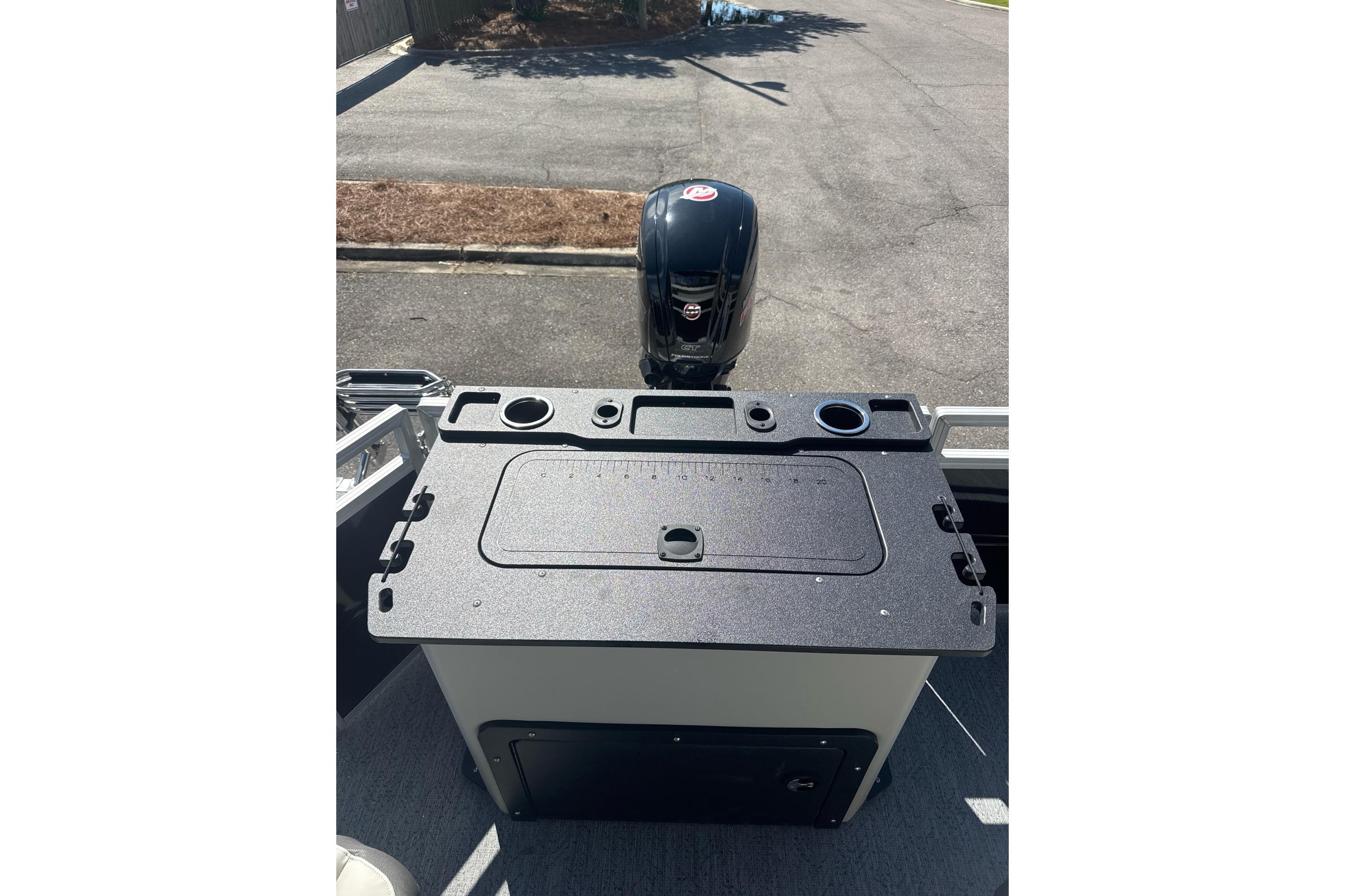 2026 Sun Tracker Fishin' Barge 20 DLX boat with motor and fishing station.