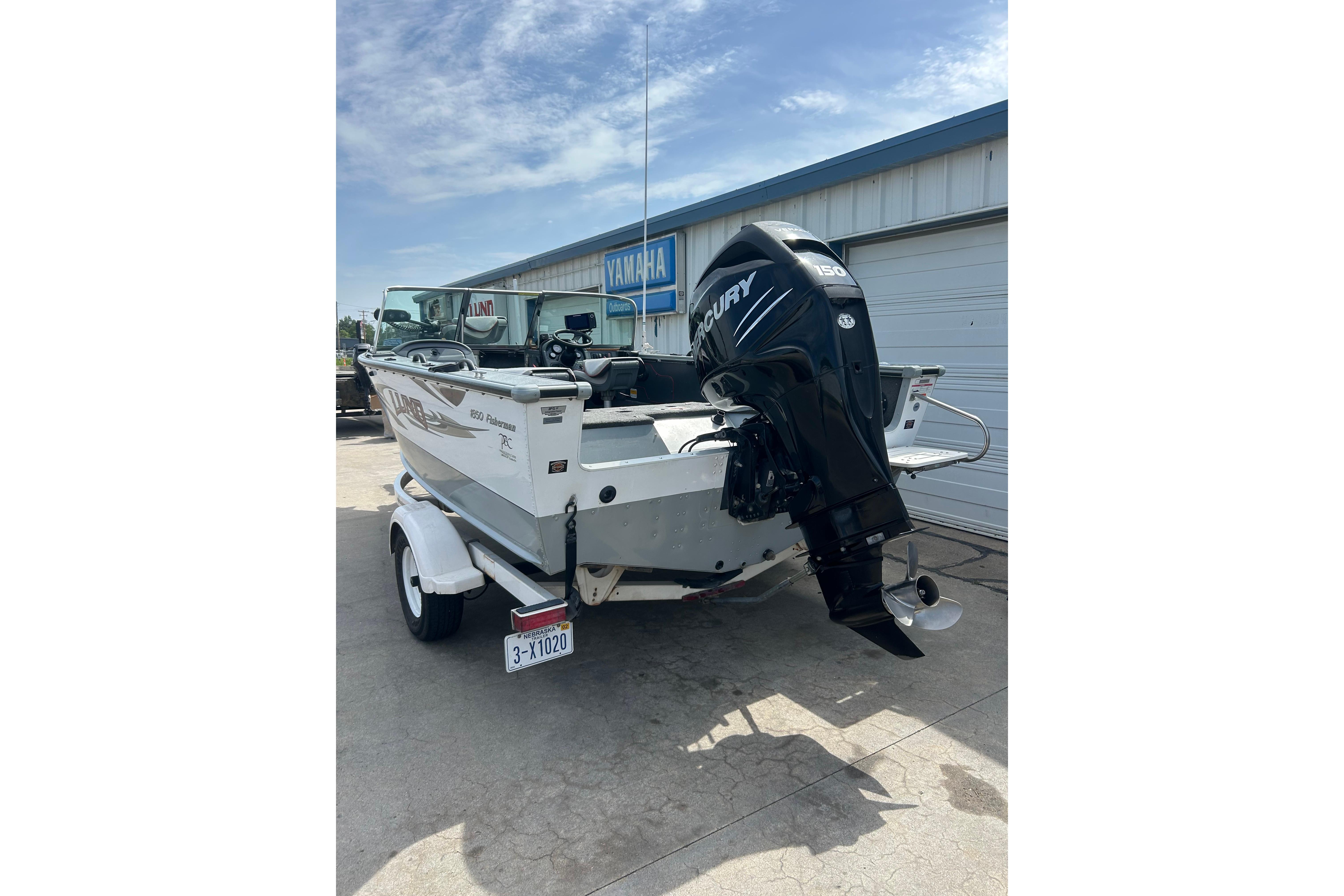 2008 Lund 1850 Fisherman boat with Mercury outboard motor, parked on a trailer.